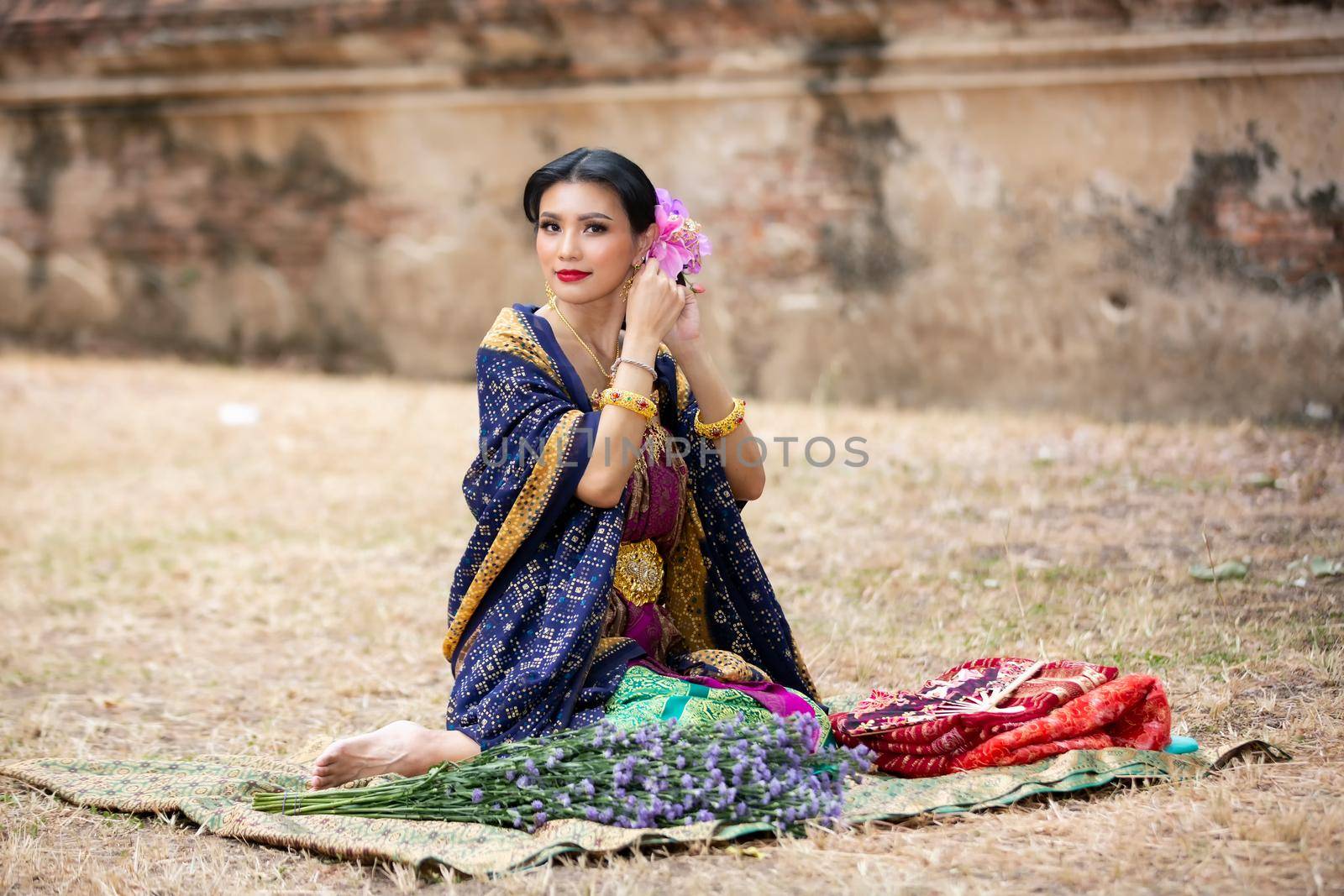 Indonesia Young beautiful woman with Traditional dress standing and look at camera at Gate to heaven Handara Golf Gate in Bedugul, Bali ,Indonesia.