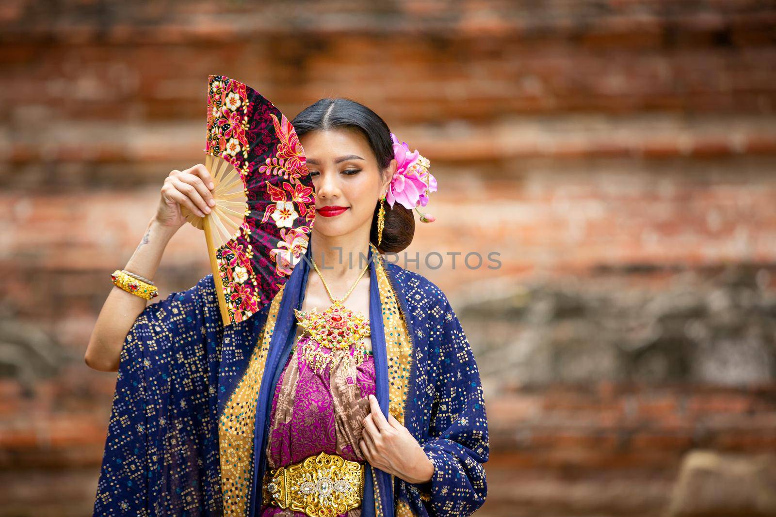 Indonesia Young beautiful woman with Traditional dress standing and look at camera at Gate to heaven Handara Golf Gate in Bedugul, Bali ,Indonesia. by chuanchai