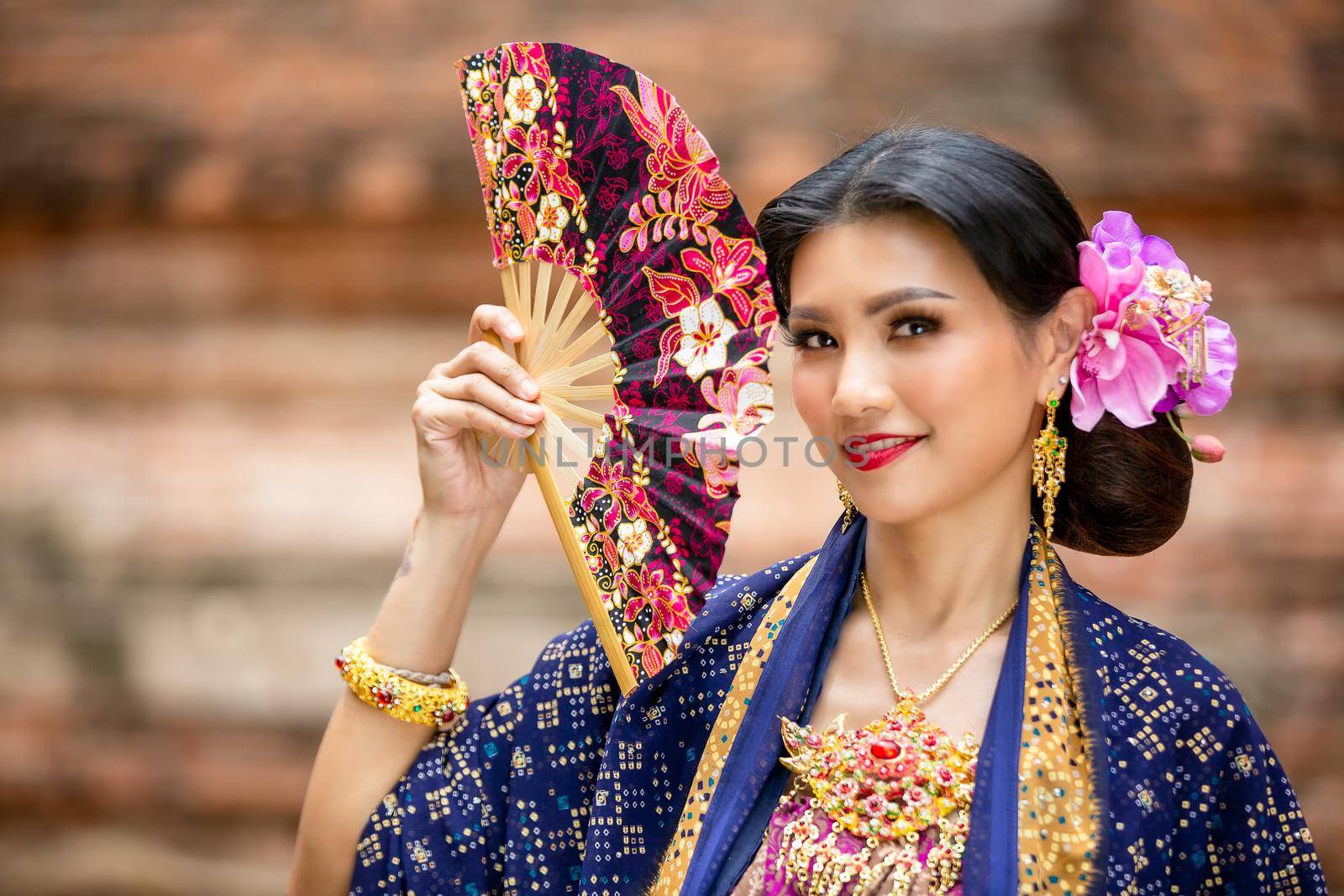 Indonesia Young beautiful woman with Traditional dress standing and look at camera at Gate to heaven Handara Golf Gate in Bedugul, Bali ,Indonesia.