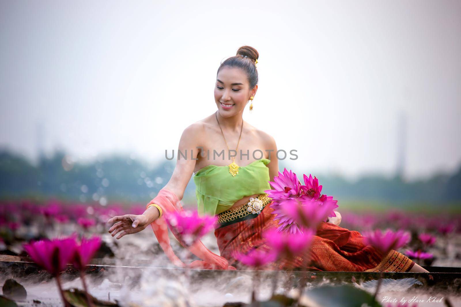 Young Asian women in Traditional dress in the boat and pink lotus flowers in the pond.Beautiful girls in traditional costume.Thai. Ayutthaya, elegance. by chuanchai