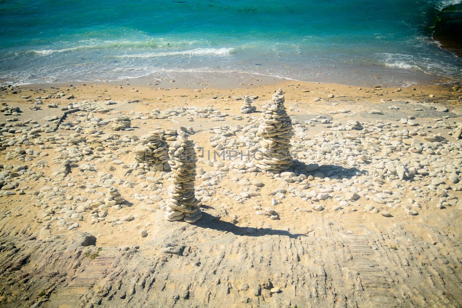 Pile of stone on the beach on the lighthouse Phare des Baleines on the isle of Ile de Ré in France on a sunny summerday