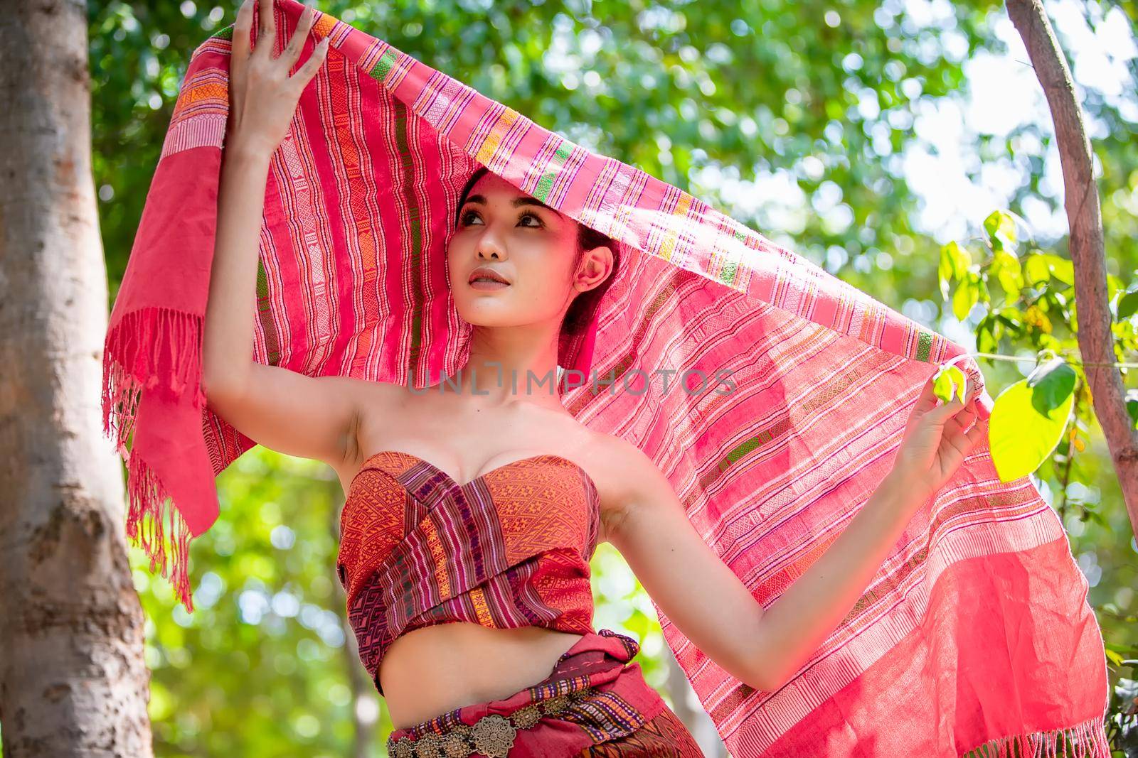 Beautiful young Asian woman dressed in traditional native dress and elephant in forest of village Surin Thailand	
