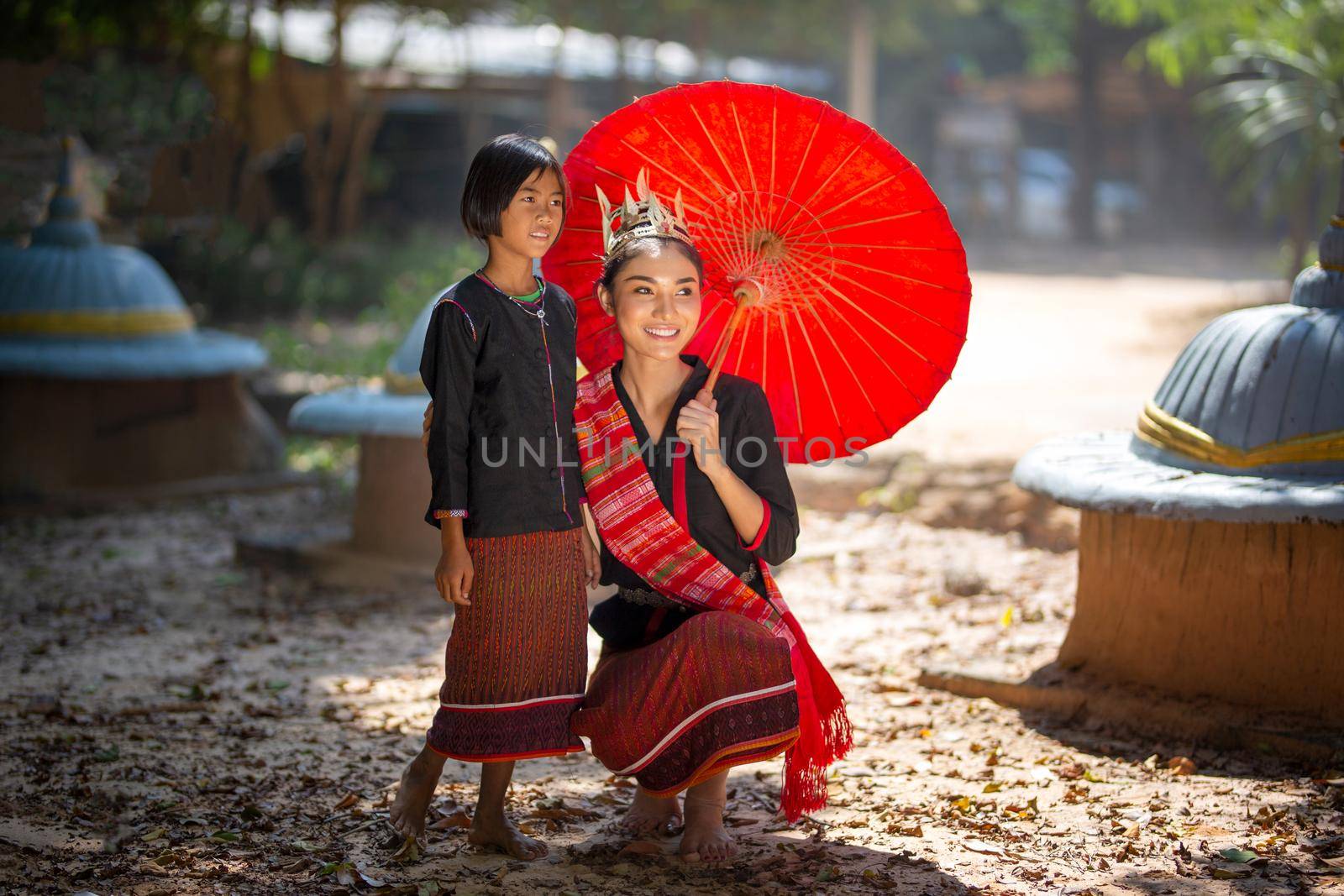 Beautiful young Asian woman dressed in traditional native dress and elephant in forest of village Surin Thailand