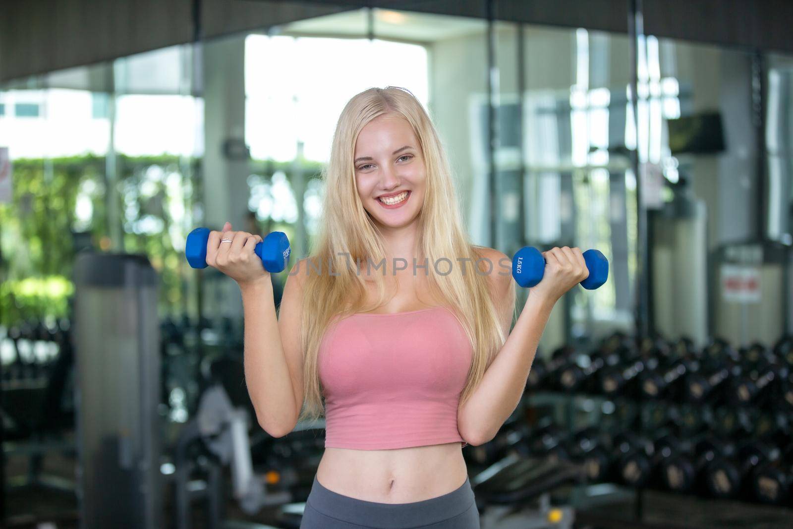 FITNESS AND WORKING OUT, active lifestyles. Young woman makes yoga pose in fitness gym.Yoga and fitness training. by chuanchai