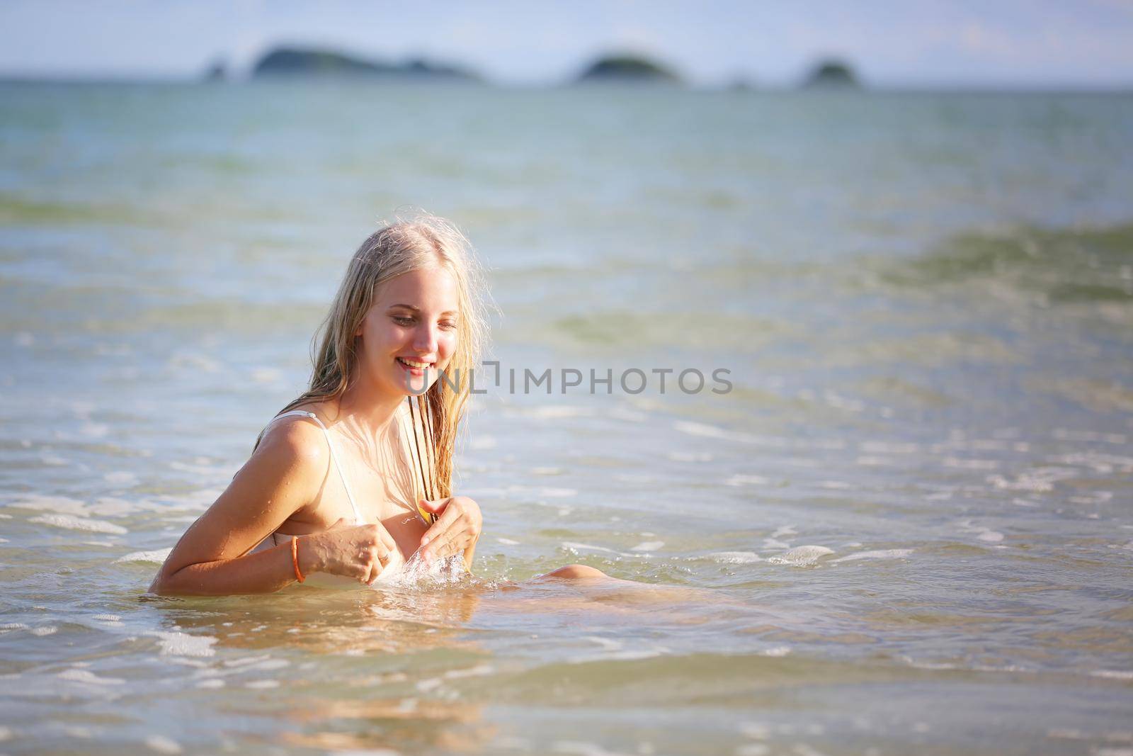 Beautiful young woman in sexy bikini on sand at sea beach.