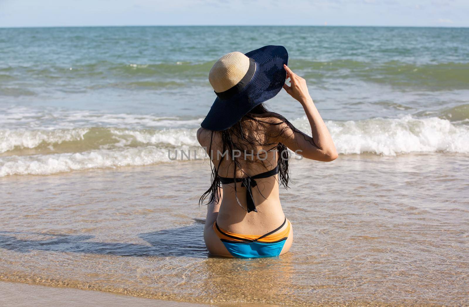 Beautiful young woman in sexy bikini on sand at sea beach.