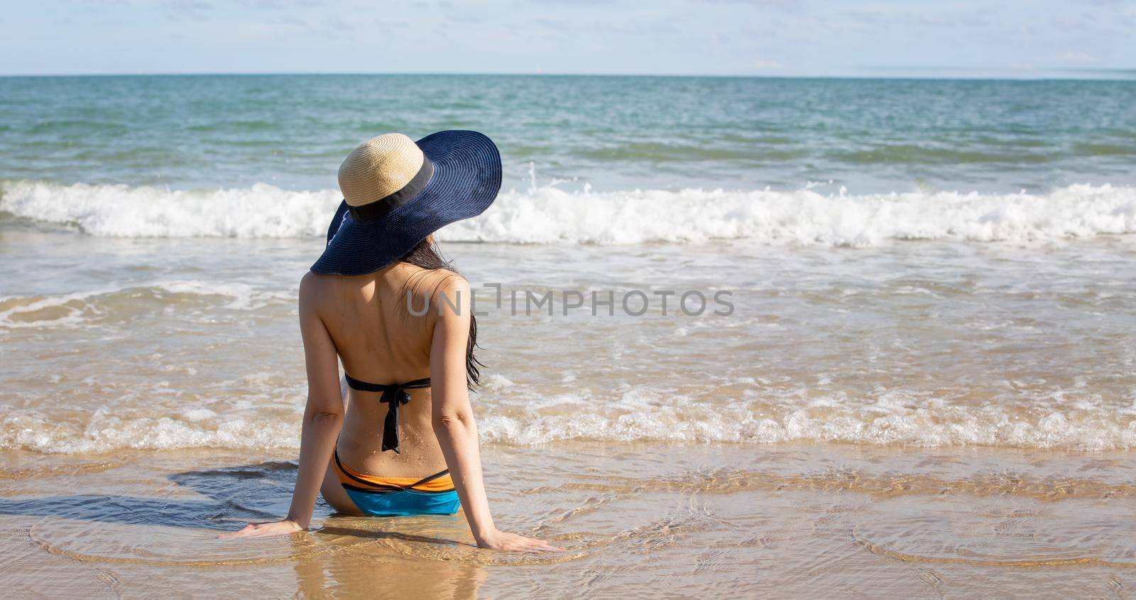 Beautiful young woman in sexy bikini on sand at sea beach.