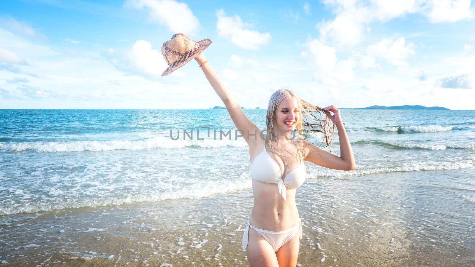 Beautiful young woman in sexy bikini on sand at sea beach.