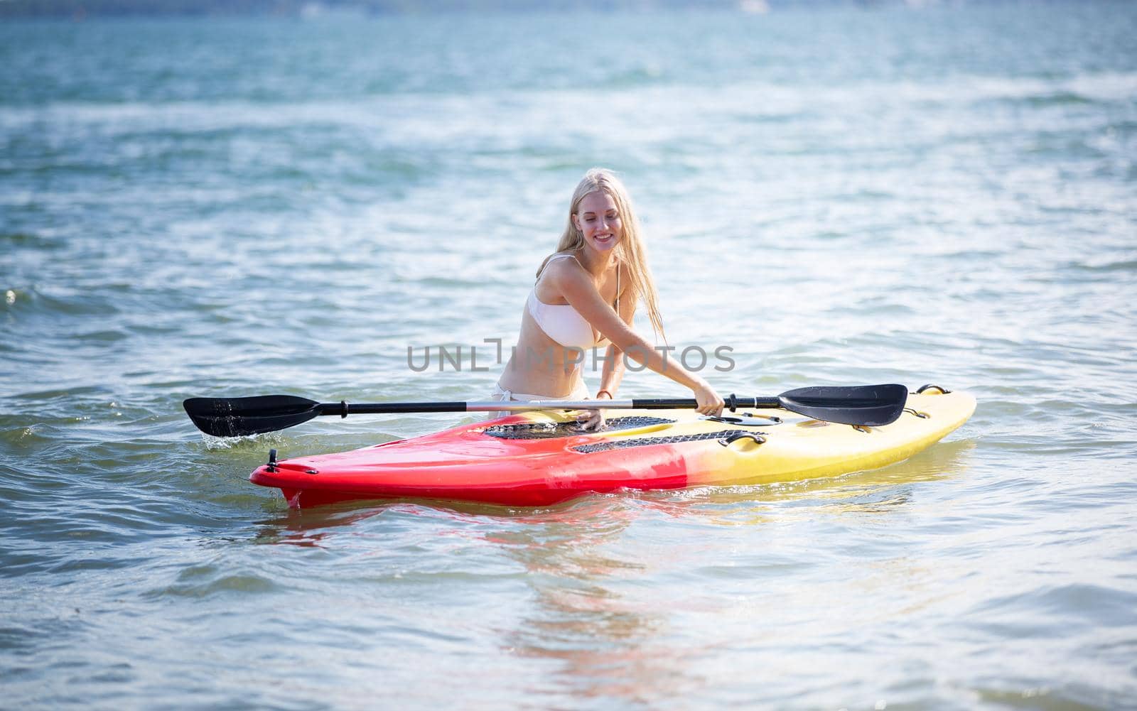 Woman on stand up paddle board. Having fun during warm summer beach vacation holiday, active woman