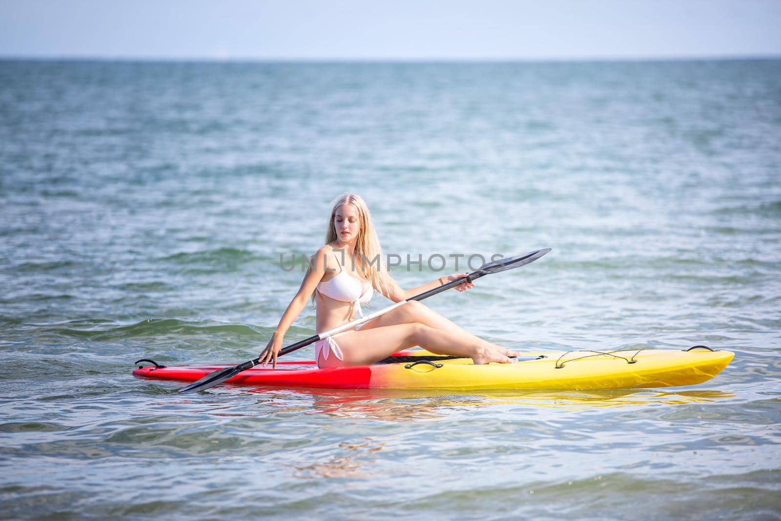 Woman on stand up paddle board. Having fun during warm summer beach vacation holiday, active woman by chuanchai
