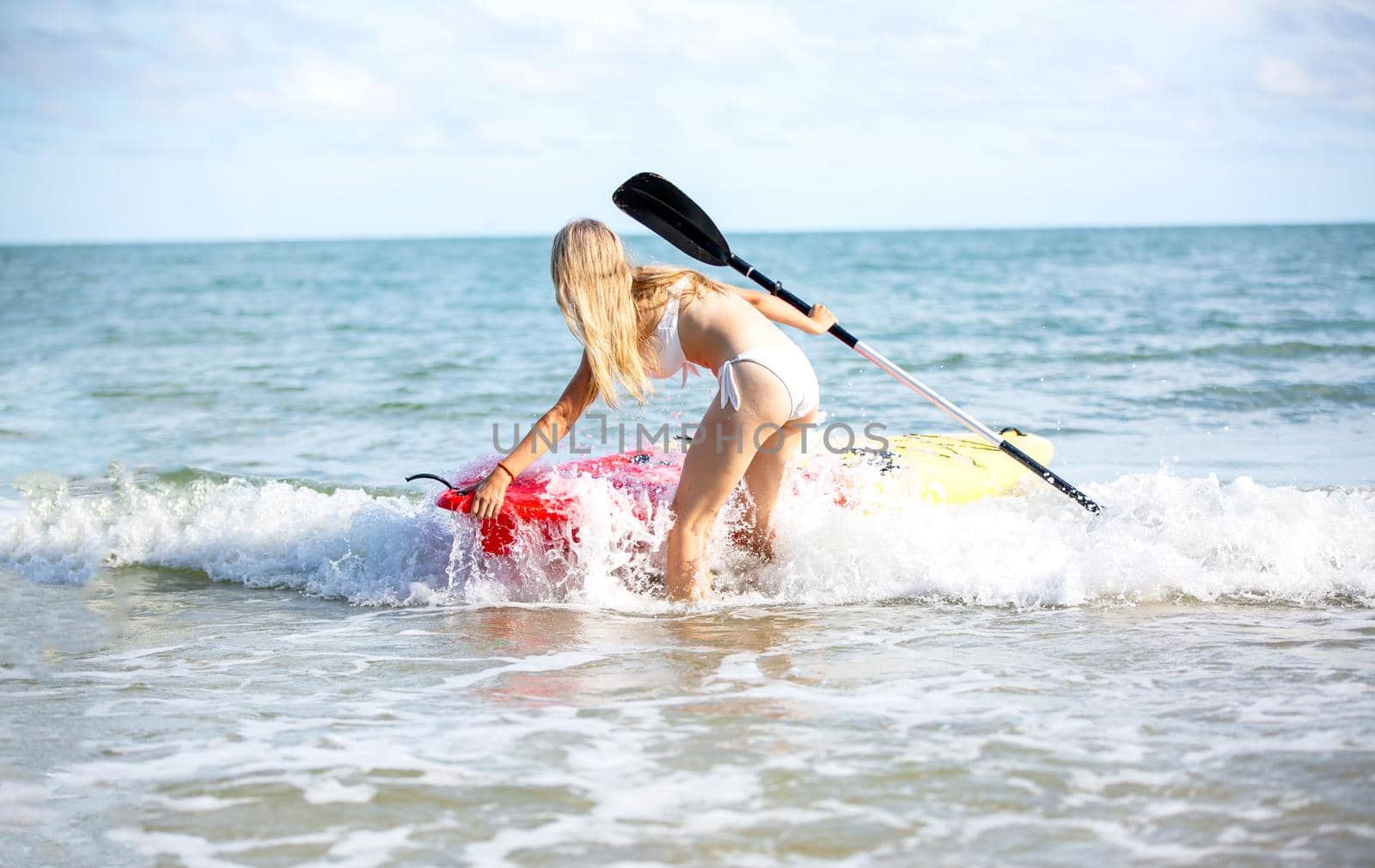 Woman on stand up paddle board. Having fun during warm summer beach vacation holiday, active woman