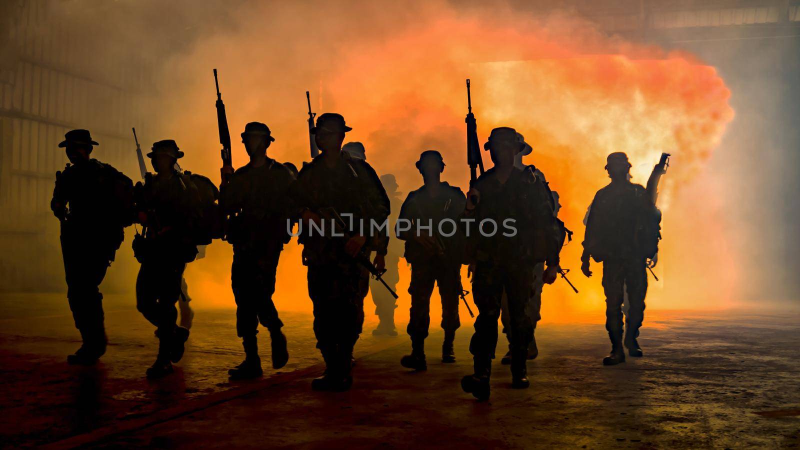Silhouettes of soldiers during Military Mission at dusk
Silhouettes of army soldiers in the fog against a sunset, marines team in action, surrounded fire and smoke, shooting with assault rifle and machine gun, attacking enemy

