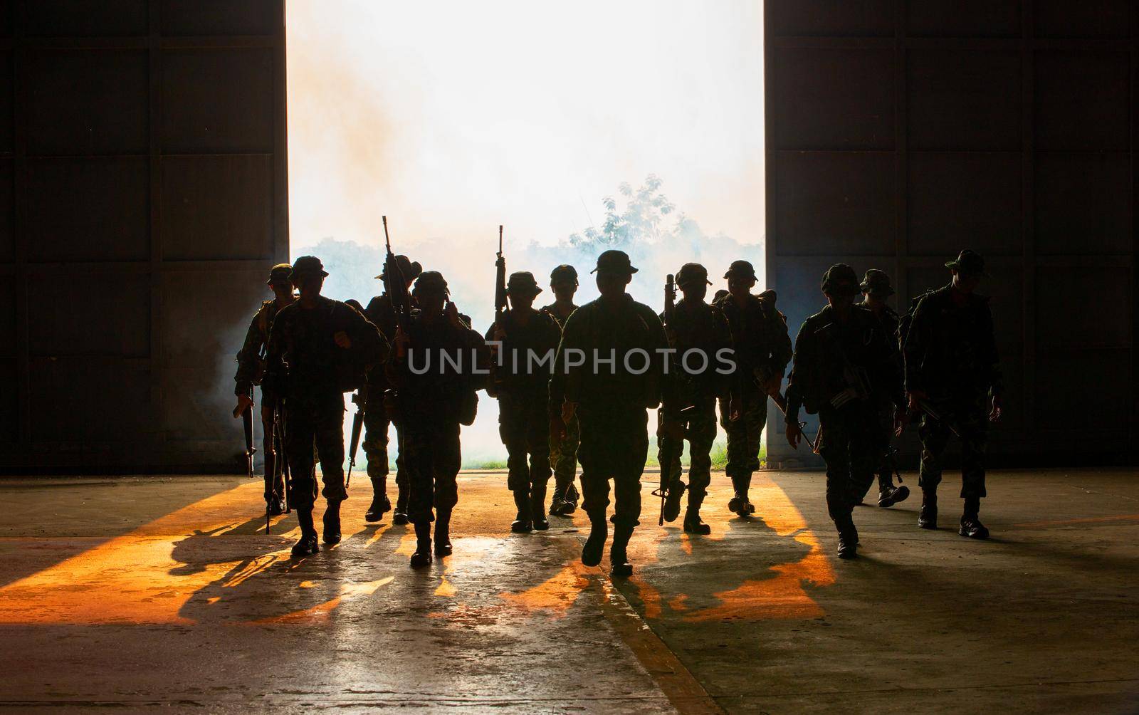 Silhouettes of soldiers during Military Mission at dusk
Silhouettes of army soldiers in the fog against a sunset, marines team in action, surrounded fire and smoke, shooting with assault rifle and machine gun, attacking enemy
 by chuanchai