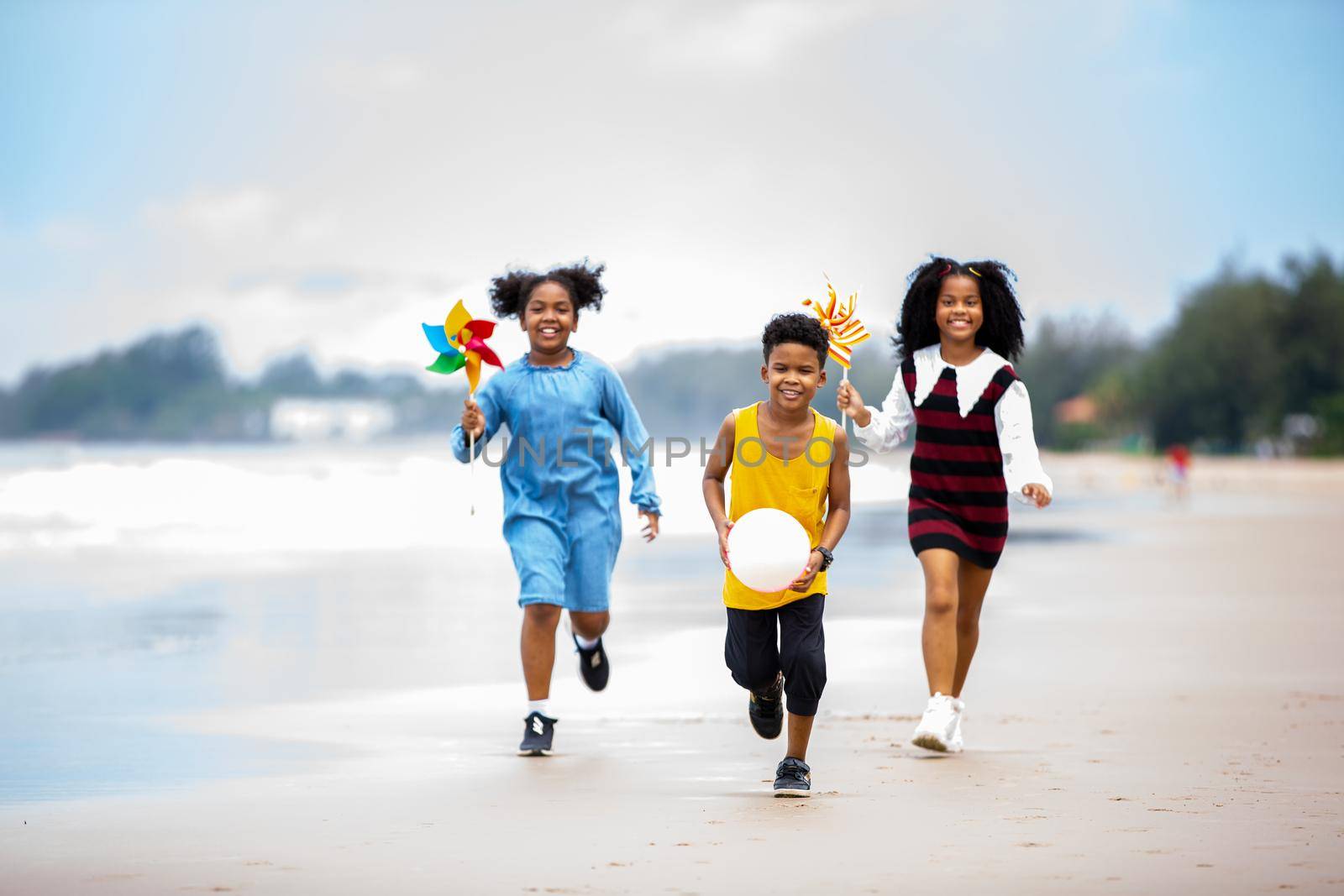 Kids playing running on sand at the beach by chuanchai