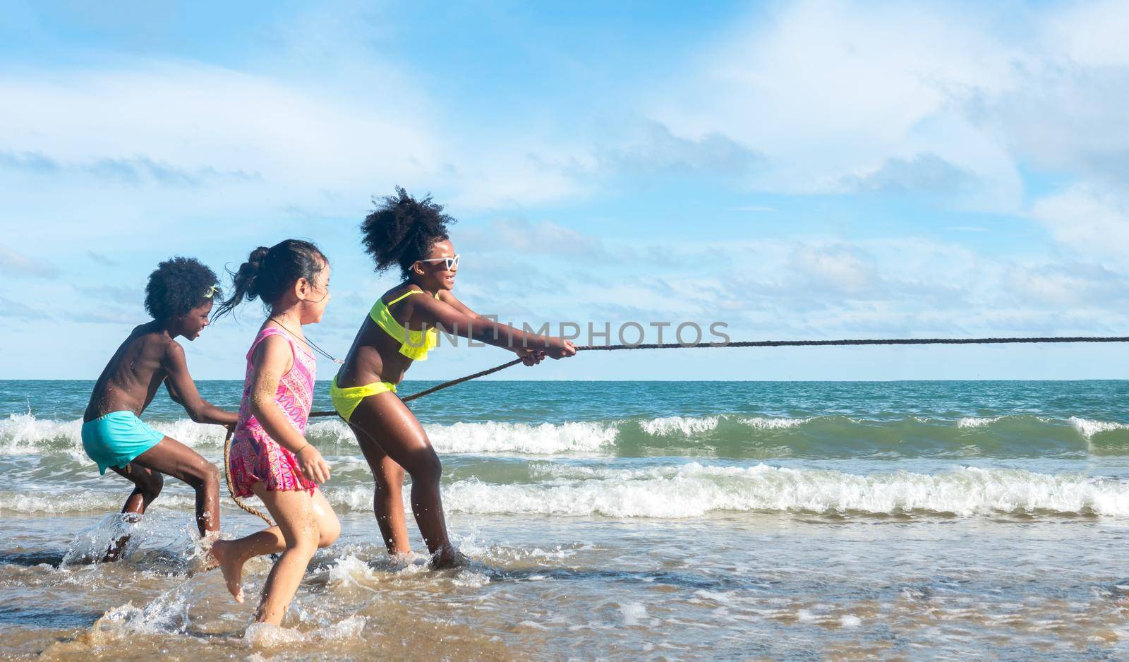 Kids playing running on sand at the beach by chuanchai