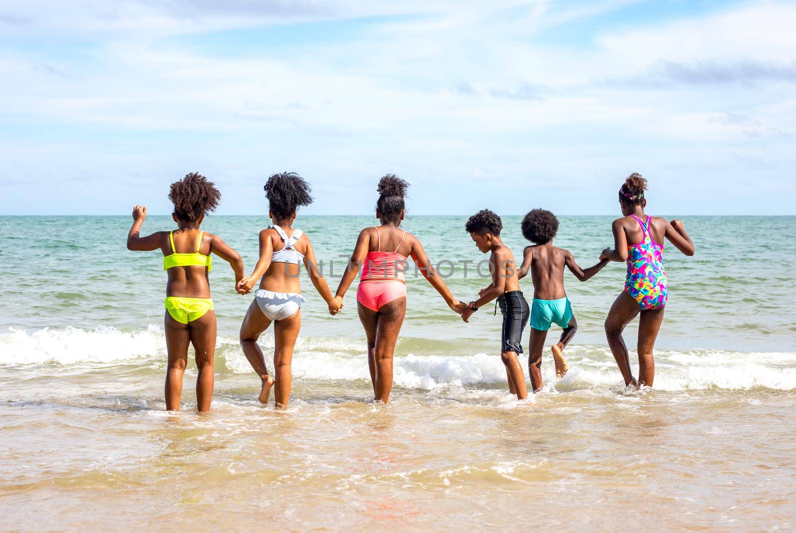 Kids playing running on sand at the beach