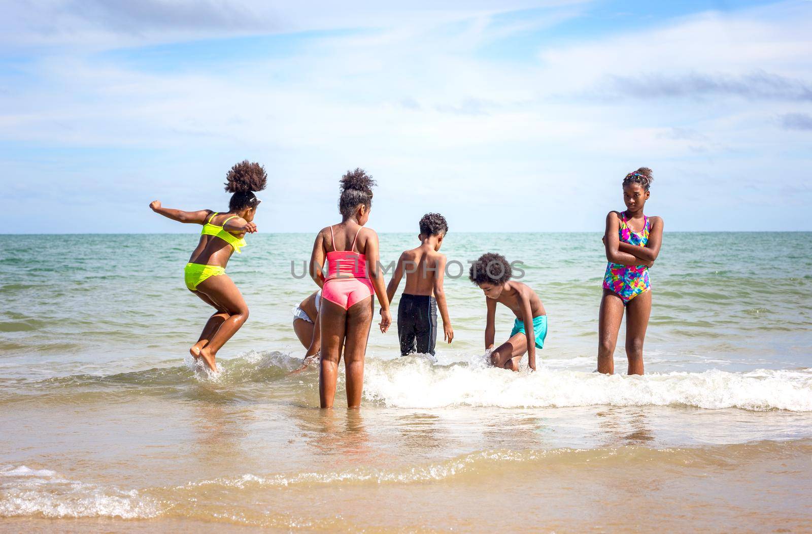 Kids playing running on sand at the beach