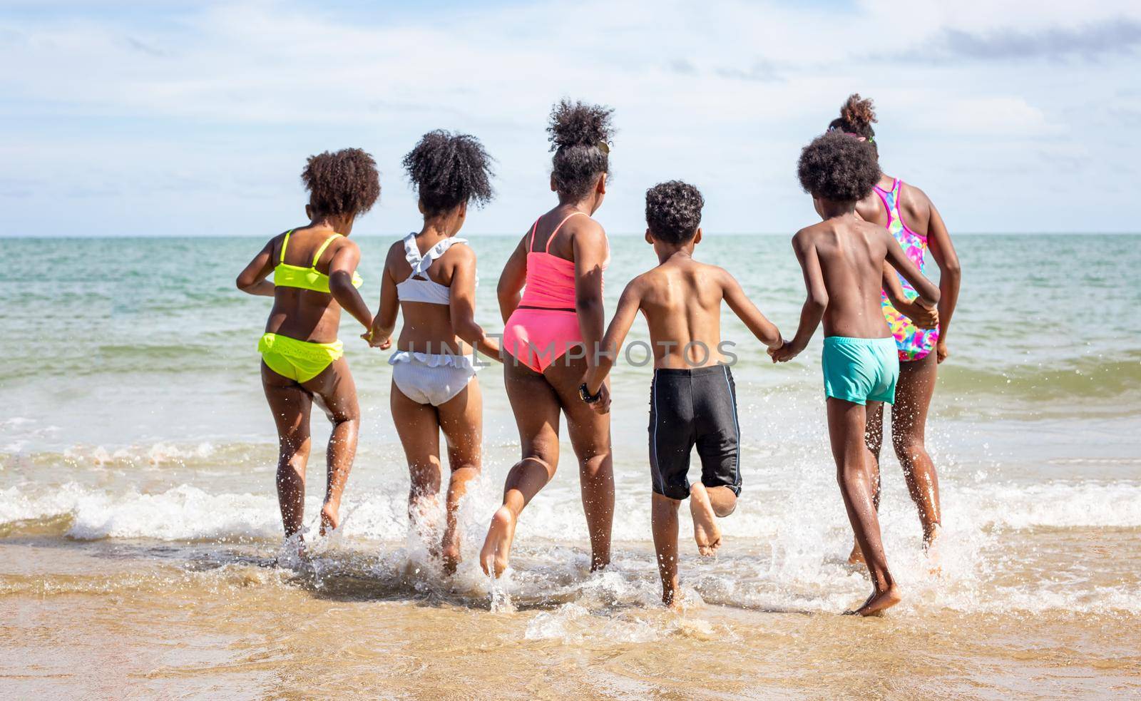 Kids playing running on sand at the beach