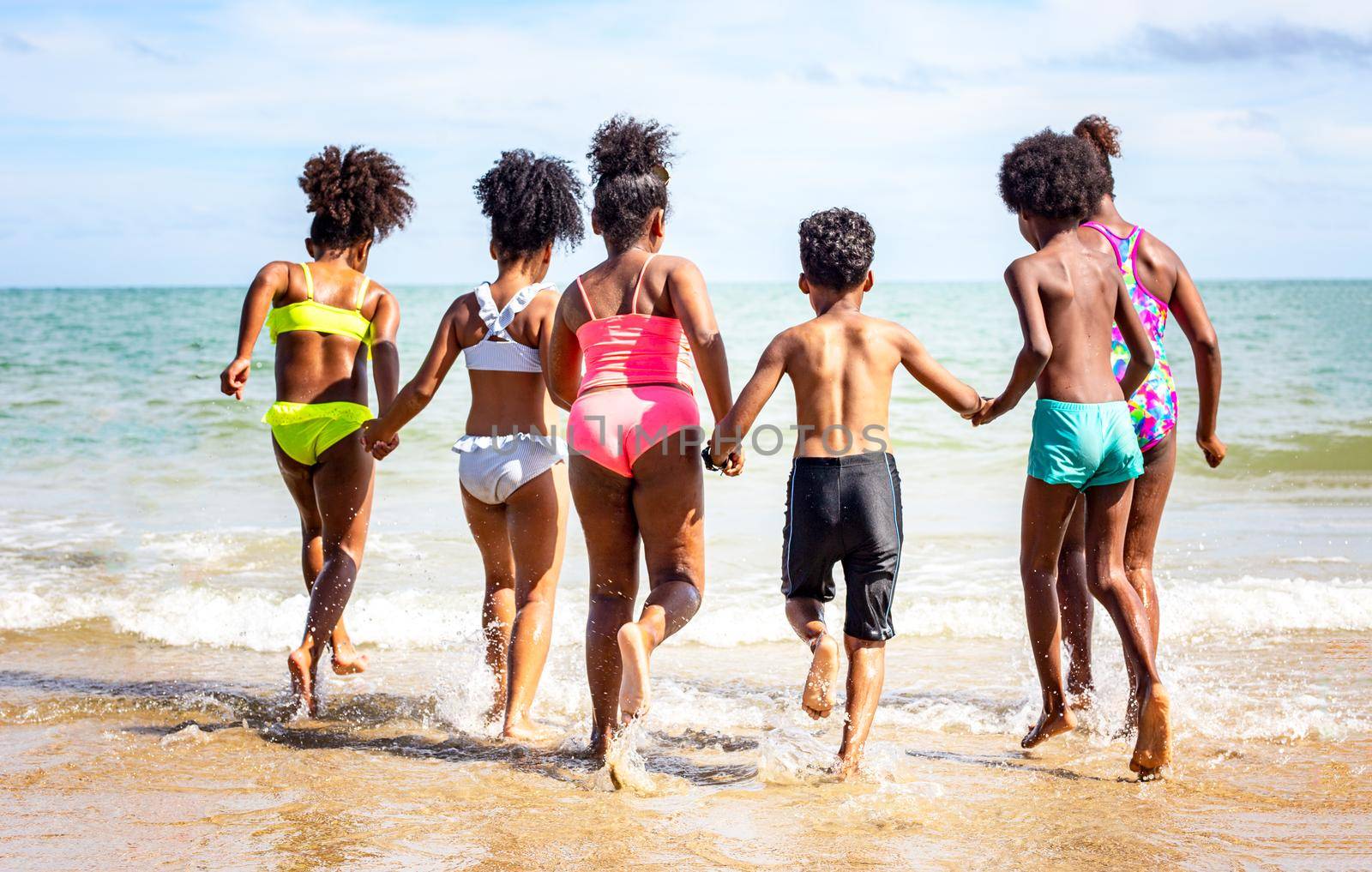 Kids playing running on sand at the beach