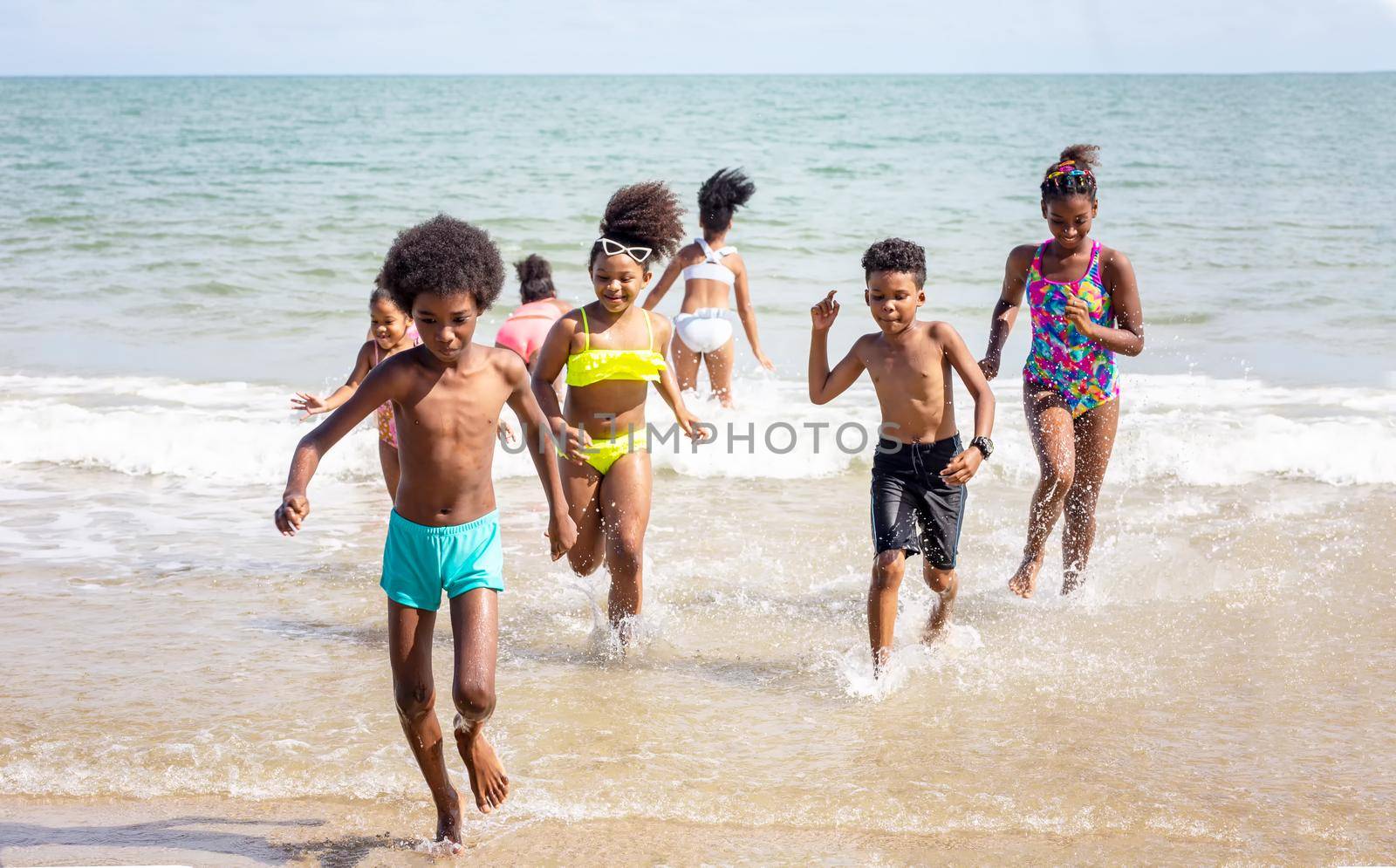 Kids playing running on sand at the beach