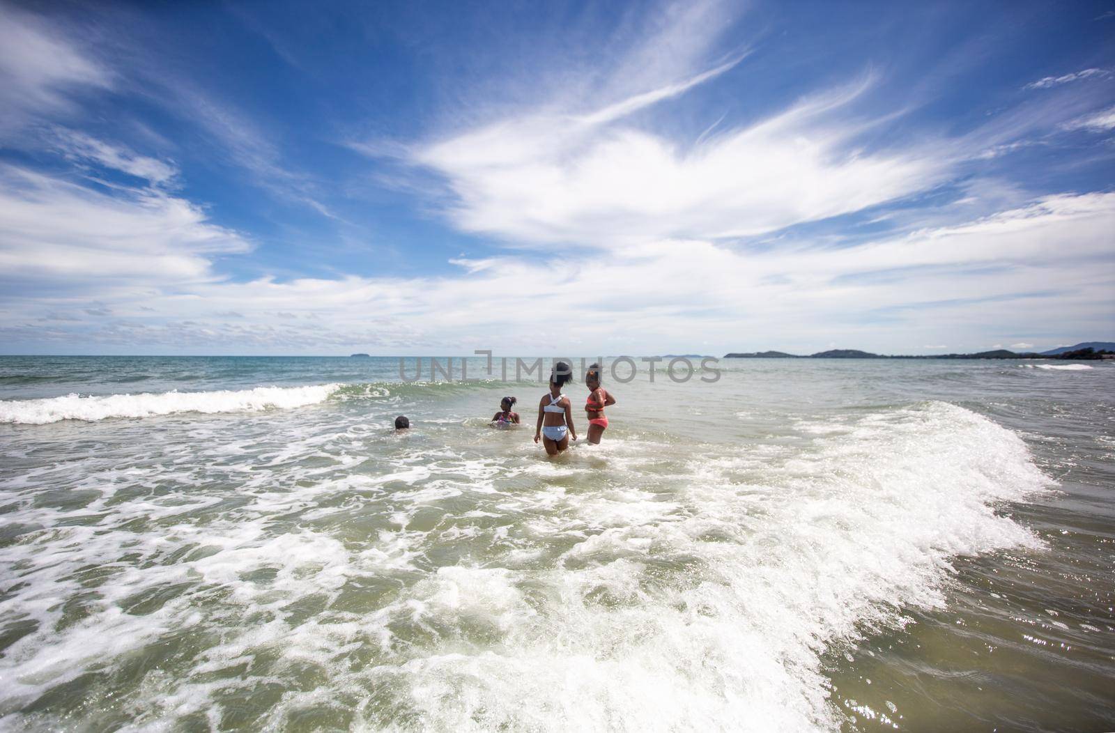 Kids playing running on sand at the beach by chuanchai