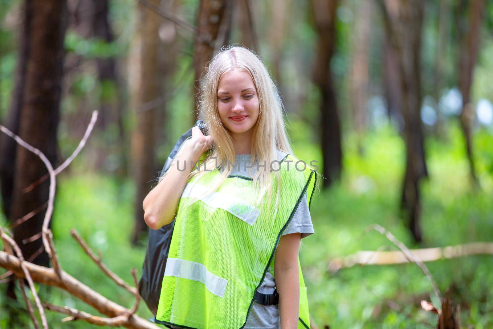 Green volunteering. Optimistic two volunteers holding garbage bag and help picking up trash at park, they're picking up the garbage and putting it in a black garbage bag. ecology protection concept.