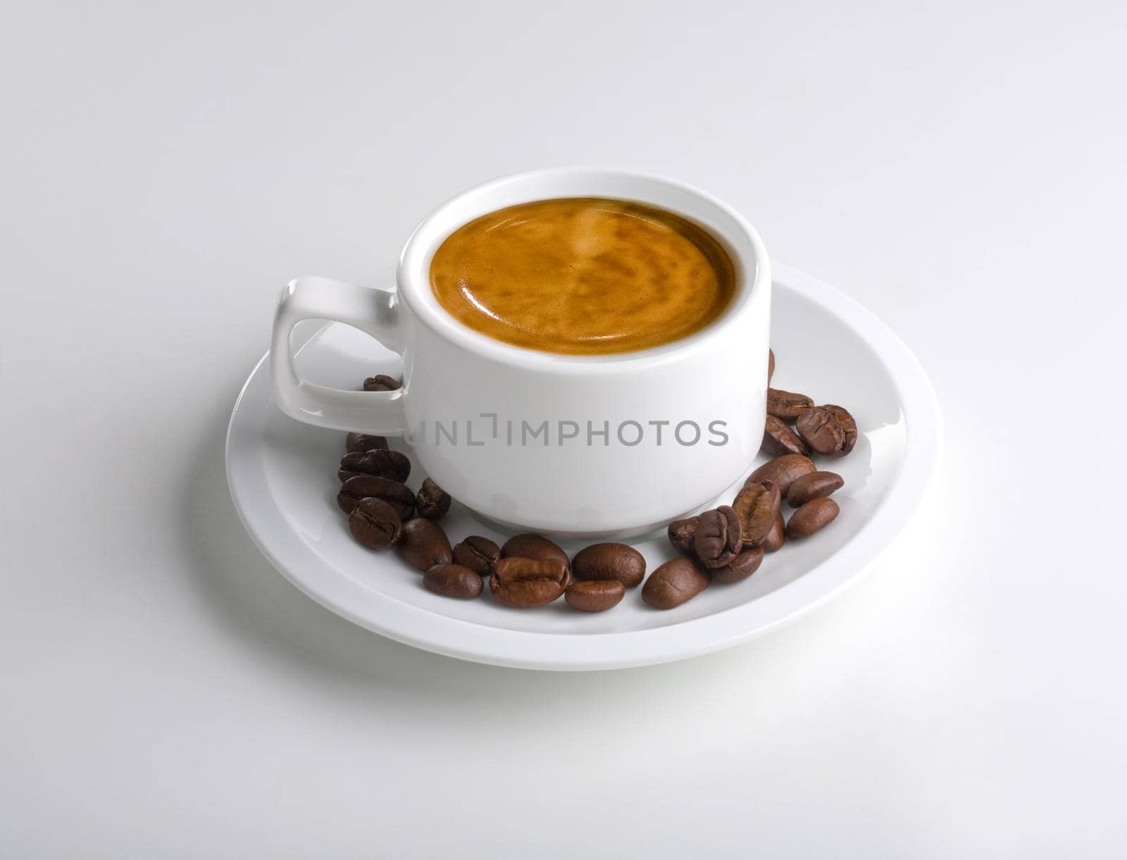 Cup of coffee on white with coffee beans