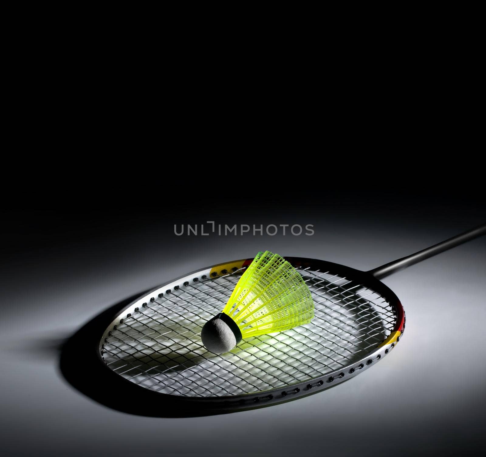 Shuttlecock and badminton on dark background