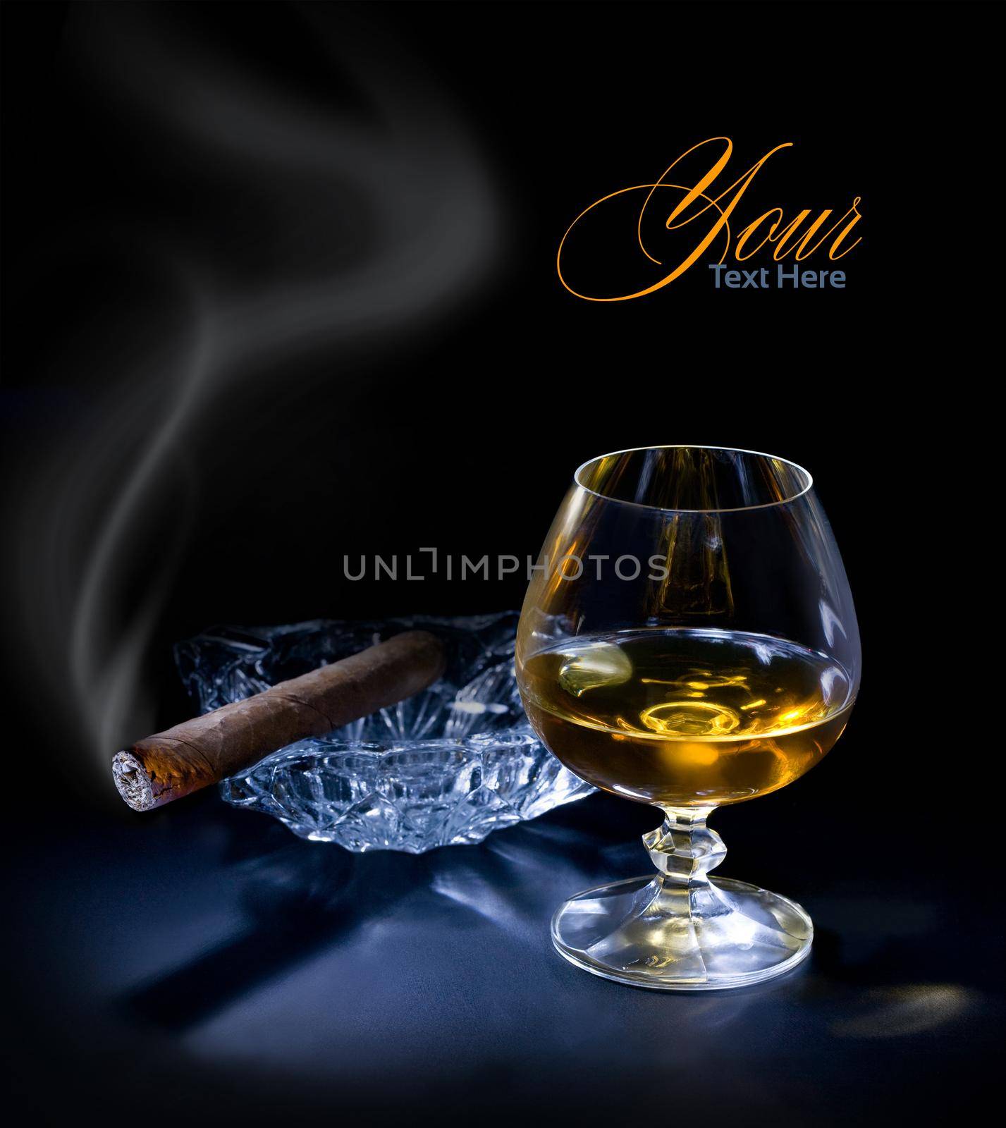 Glass of cognac with a cigar on dark sackground