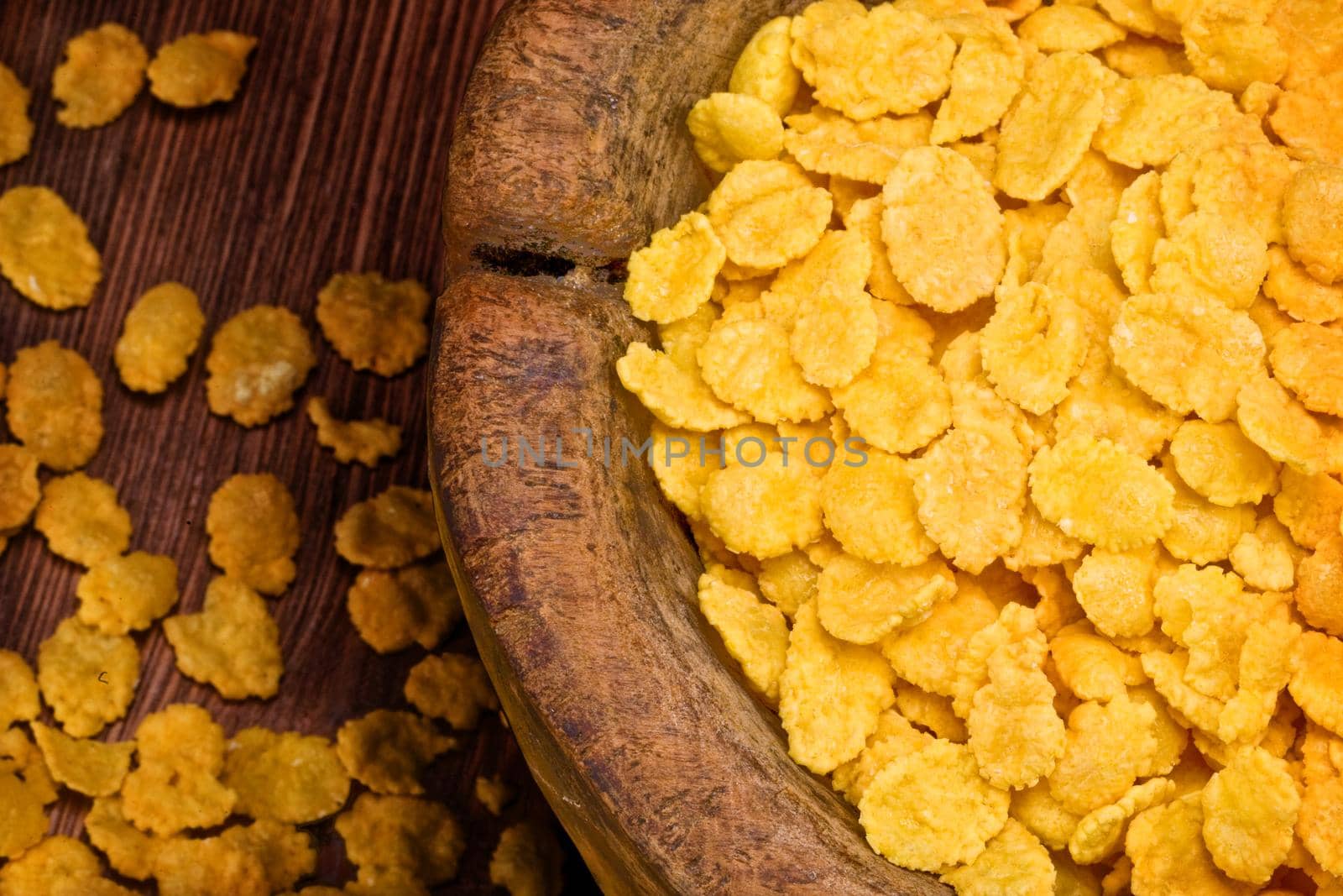 cornflakes on wooden bowl close up