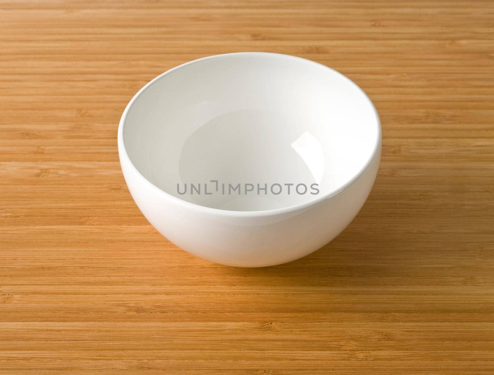 white empty bowl on a bamboo table top