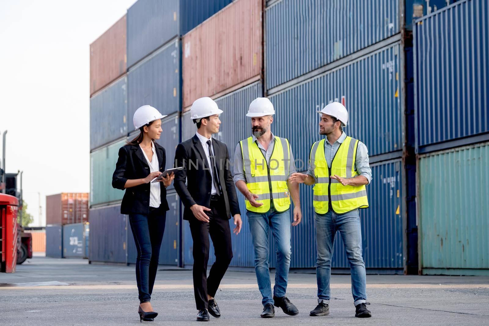 Group of cargo container workers or factory and engineer technicians walk and discuss together in workplace area. Concept of good teamwork support best success work of industrial business. by nrradmin