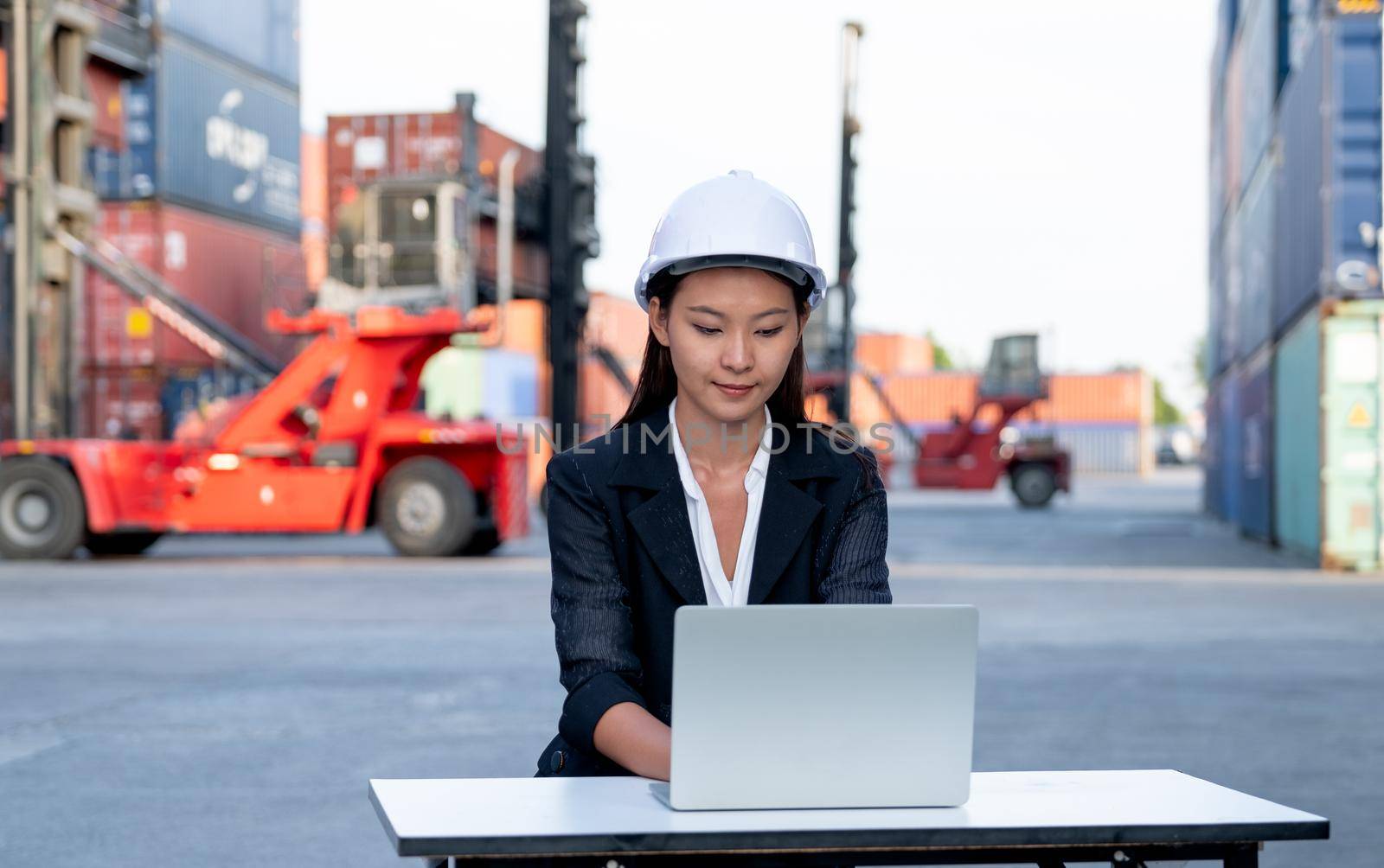 Portrait of engineer worker of factory technician with Chinese woman style sit and work with laptop in workplace area. Concept of good support best successful for industrial business.