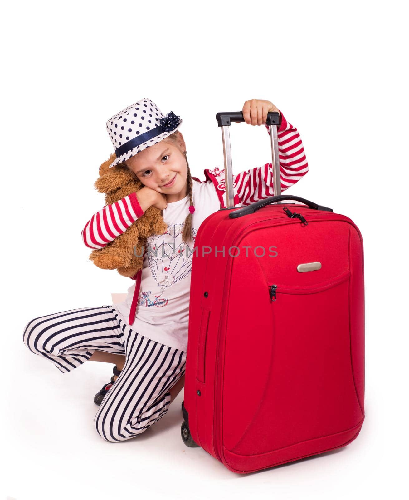 Portrait of little girl with travel case and hat isolated on white by aprilphoto