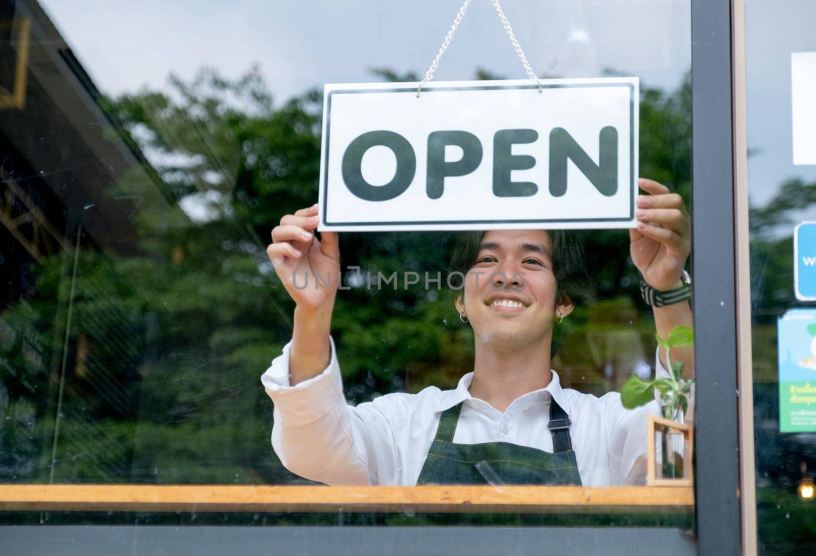 Barista or coffee maker man hold banner of open for the symbol of ready to service for customer. Concept of happy working with small business and sustainable.