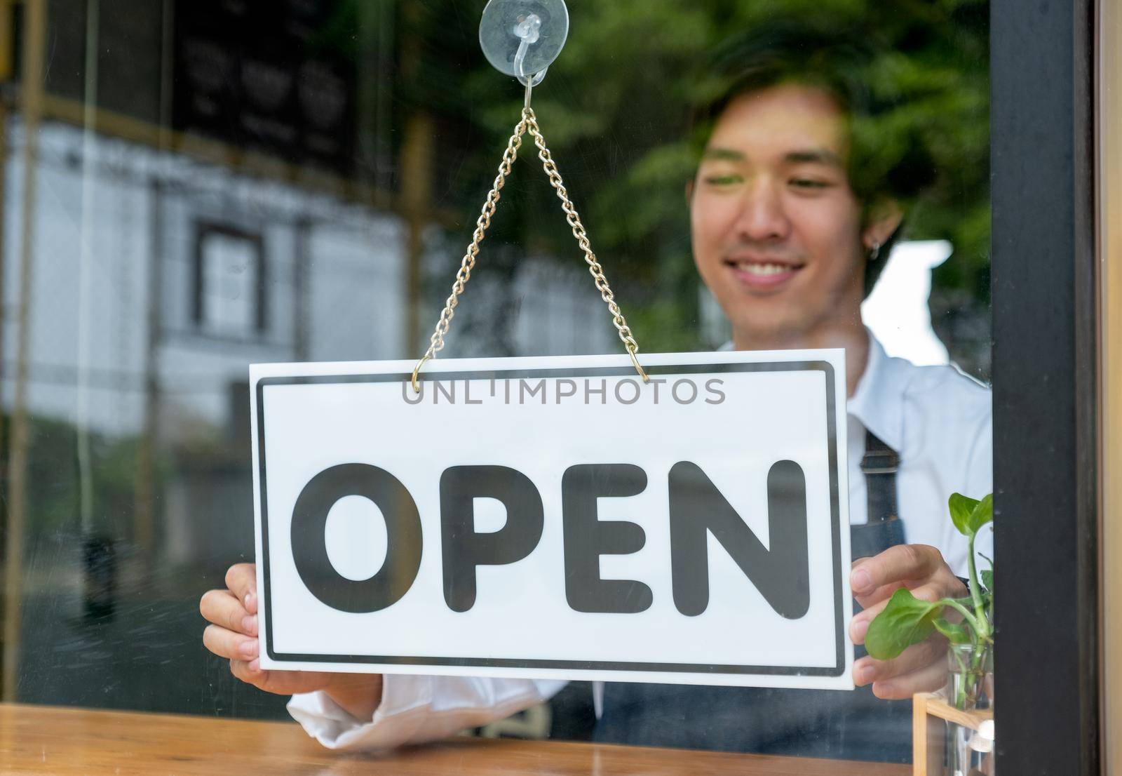 Barista or coffee maker man hold banner of open for the symbol of ready to service for customer. Concept of happy working with small business and sustainable.