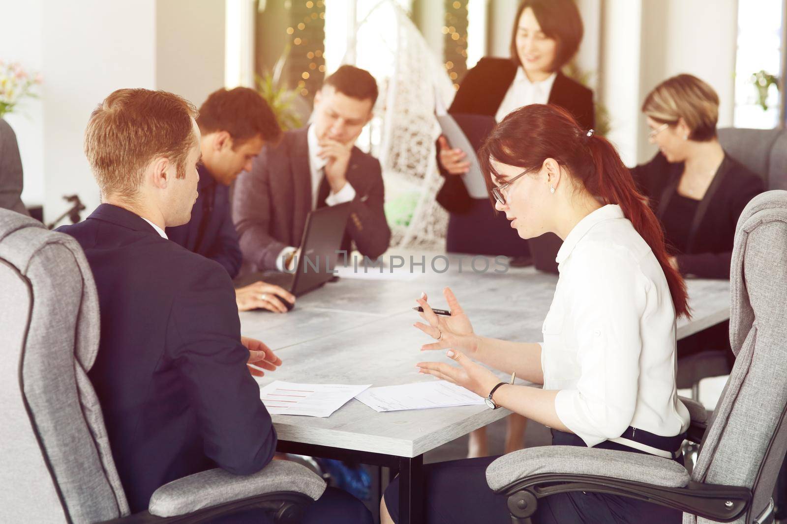 Group of young successful businessmen lawyers communicating together in a conference room while working on a project by selinsmo