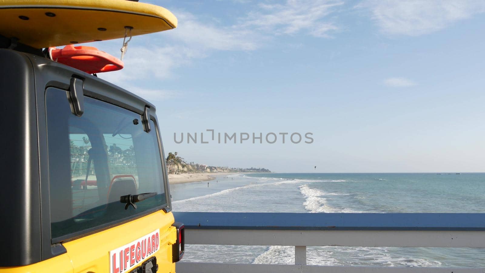 Yellow lifeguard car, San Clemente beach pier, California USA. Coastline rescue life guard pick up truck, lifesavers vehicle. Auto and ocean coast. Los Angeles vibes, summertime aesthetic atmosphere.