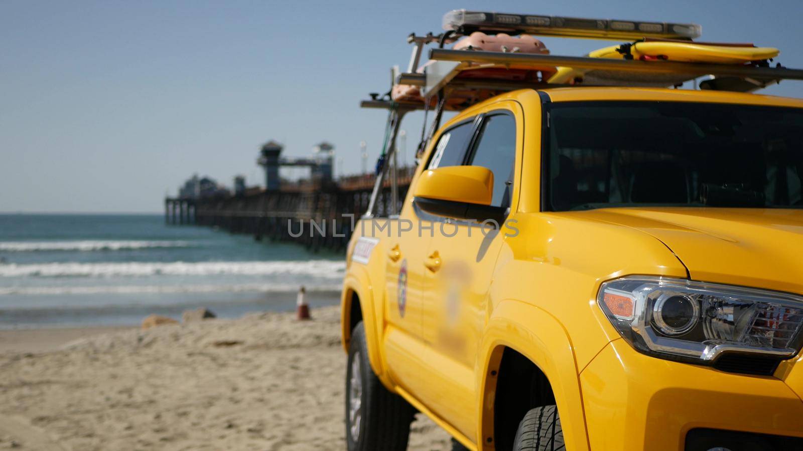 Yellow lifeguard car, Oceanside beach, California USA. Coastline rescue life guard pick up truck, lifesavers vehicle. Iconic auto and ocean coast. Los Angeles vibes, summertime aesthetic atmosphere.