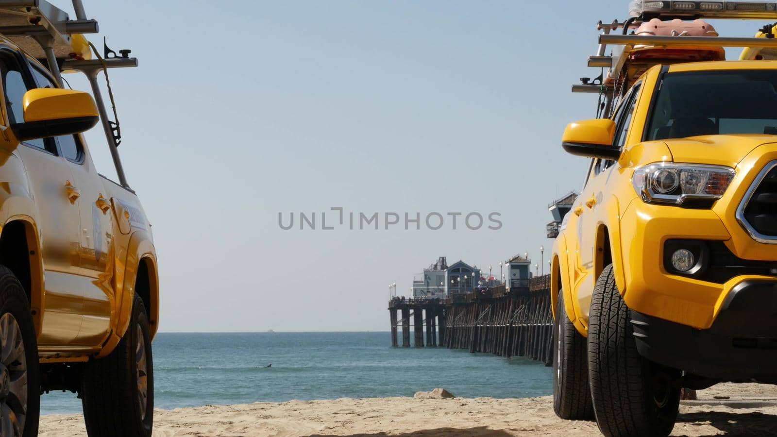 Yellow lifeguard car, Oceanside beach, California USA. Coastline rescue life guard pick up truck, lifesavers vehicle. Iconic auto and ocean coast. Los Angeles vibes, summertime aesthetic atmosphere.