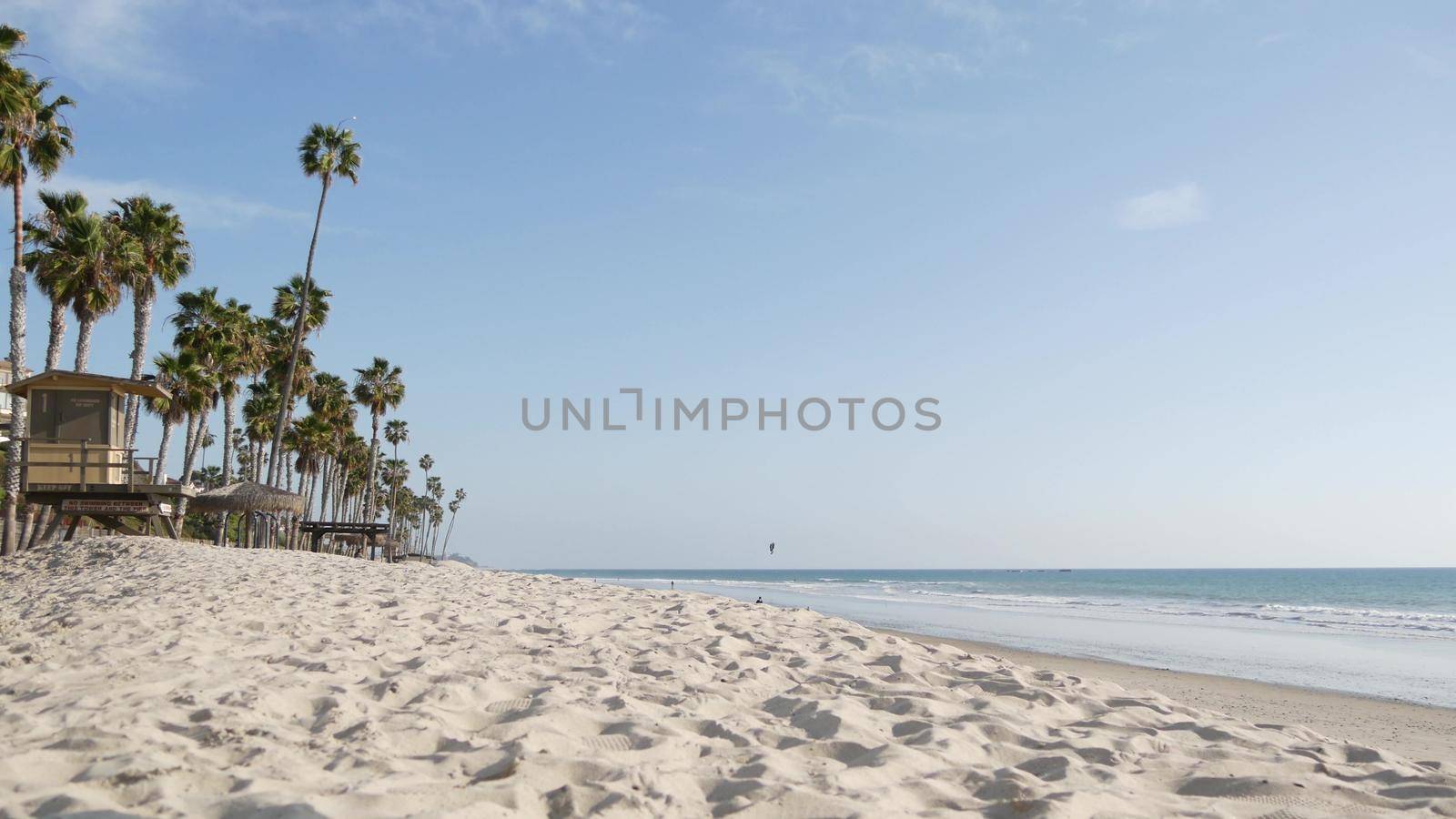 Palm trees on white sandy beach, ocean sea coast in California USA. Lifeguard tower, watchtower hut. by DogoraSun