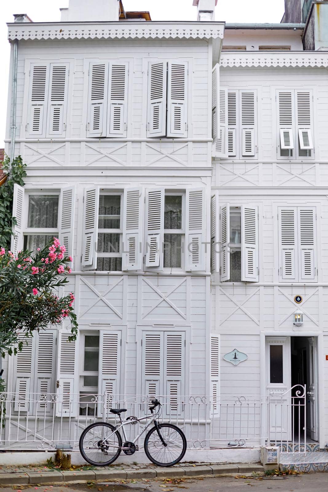 An old white building with a bike parked. Streets of the island of Buyukada.