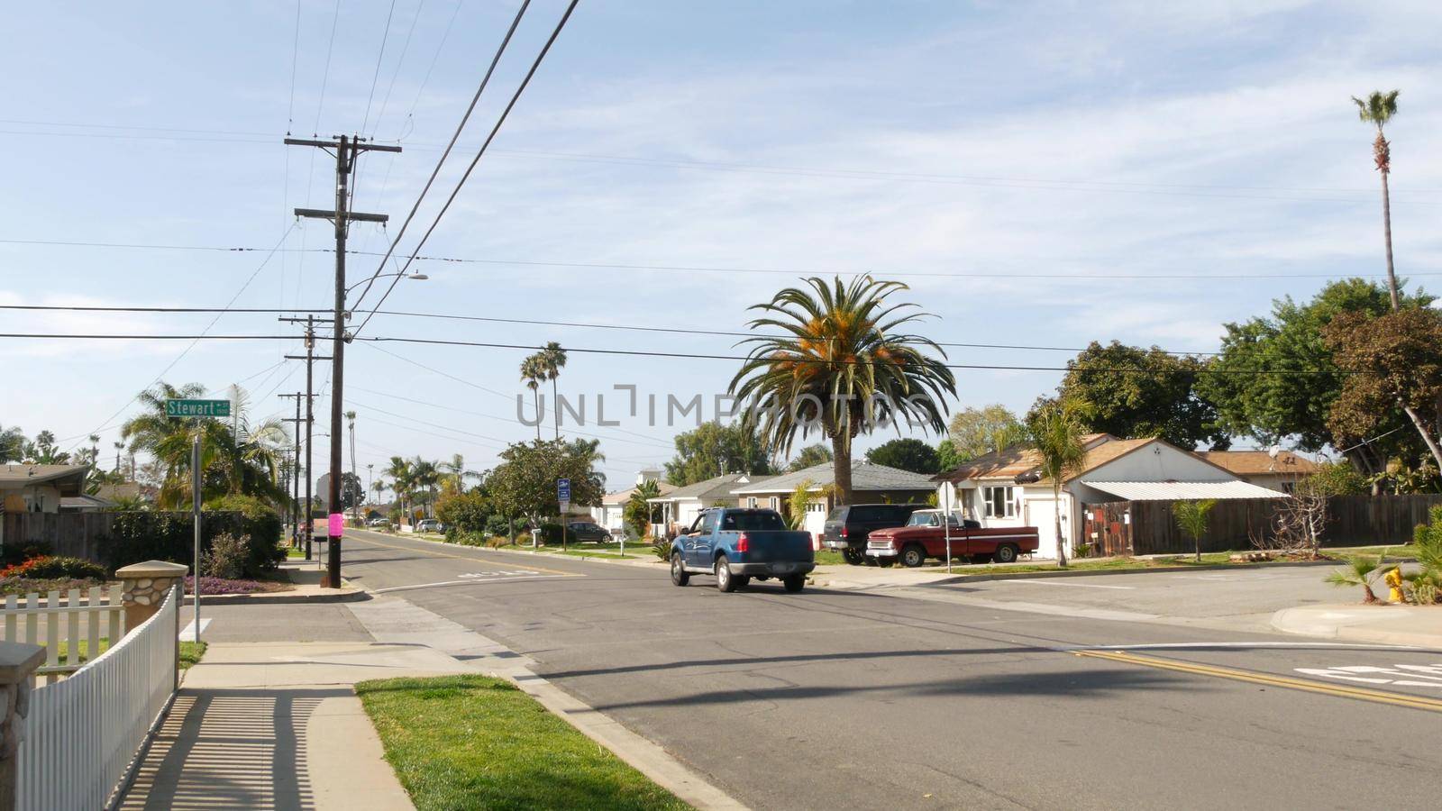 Houses on suburban street in California USA, Oceanside. Generic buildings in residential district near Los Angeles. Real estate property exterior. Tropical gardens, palms near typical american homes.