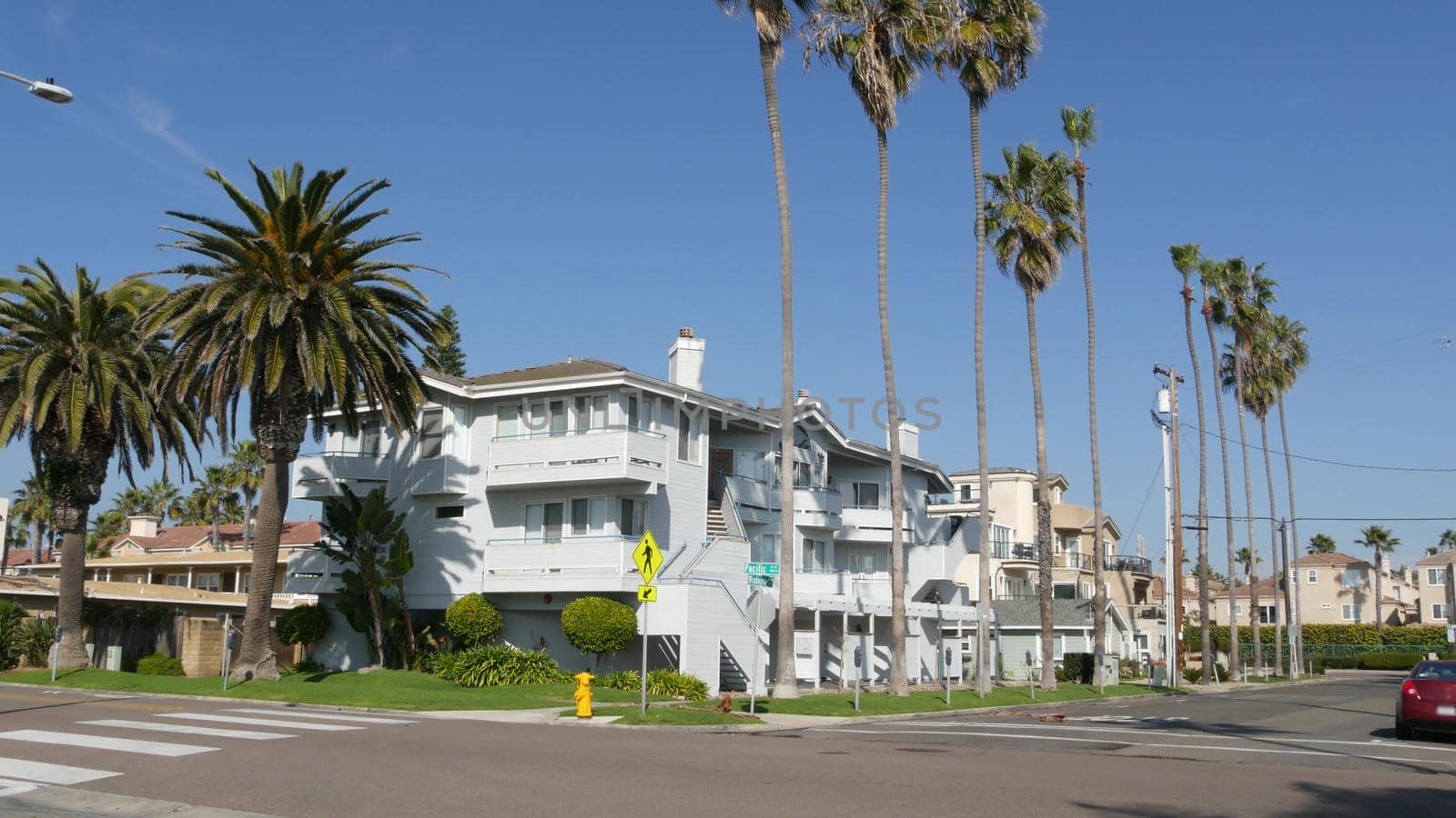 Houses on suburban street in California USA, Oceanside. Generic buildings in residential district near Los Angeles. Real estate property exterior. Tropical gardens, palms near typical american homes.