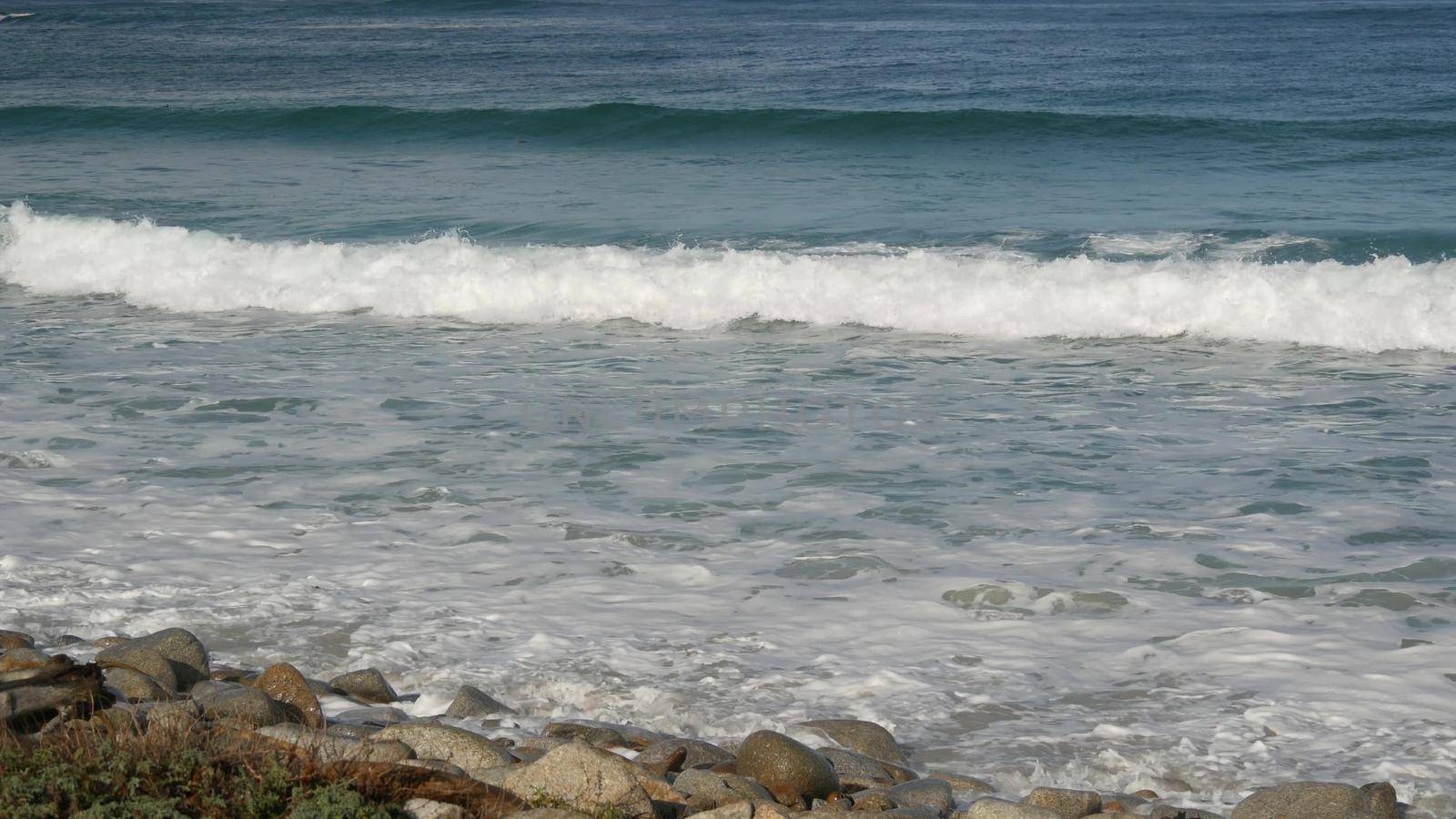 Ocean waves and rocks, Monterey, Northern California, USA. 17-mile drive near Big Sur, seaside golf tourist resort on Pacific Coast Highway. Splashing water and sea breeze of Pebble beach. Road trip by DogoraSun