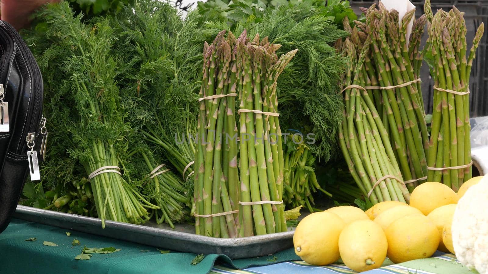 Organic vegetables on counter, fresh local produce homegrown raw veggies on marketplace stall. Healthy vegetarian food, Farmers market in Oceanside California USA. Agricultural farm harvest selling.
