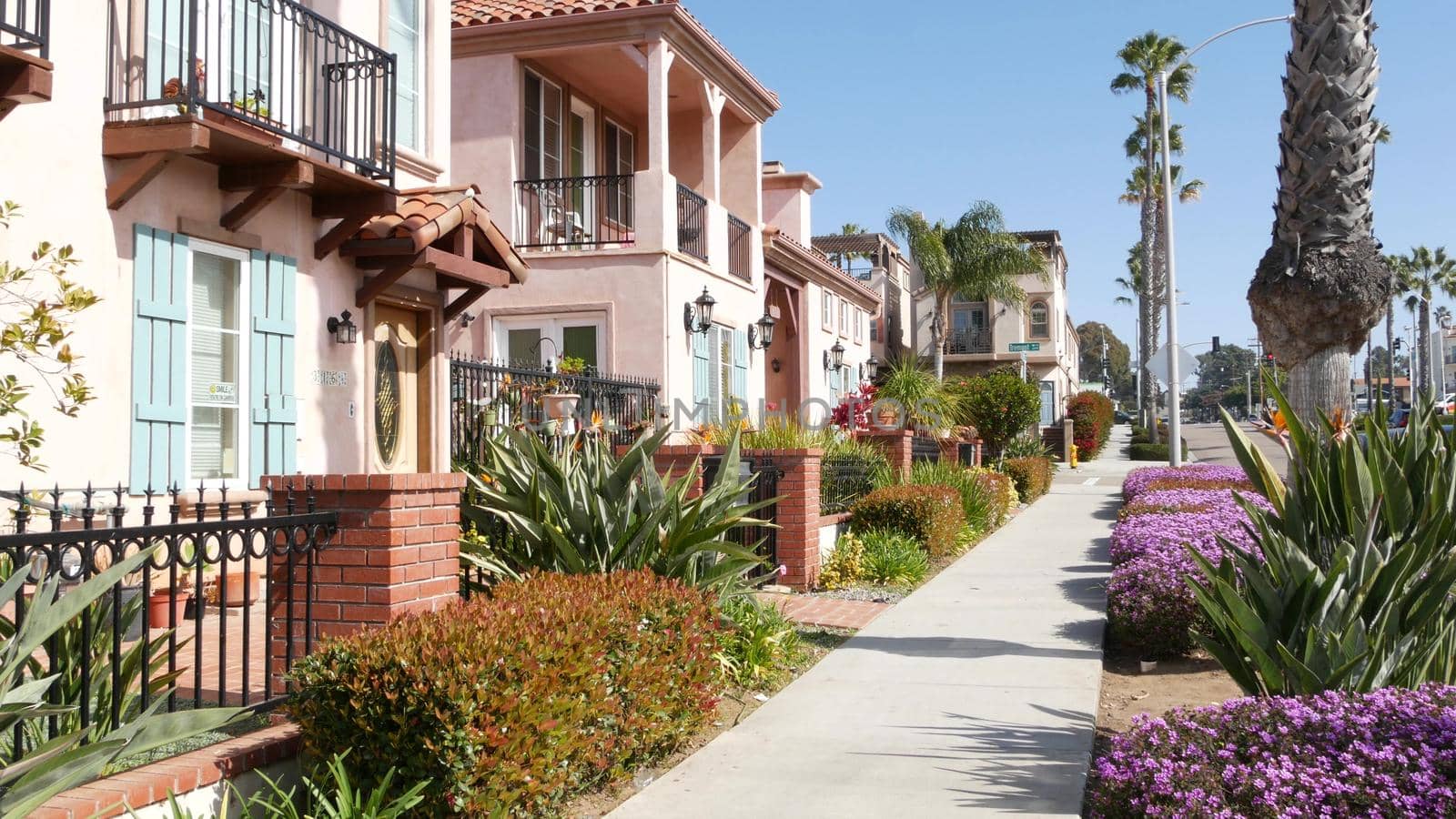 Houses on suburban street in California USA, Oceanside. Generic buildings in residential district near Los Angeles. Real estate property exterior. Tropical gardens, palms near typical american homes.