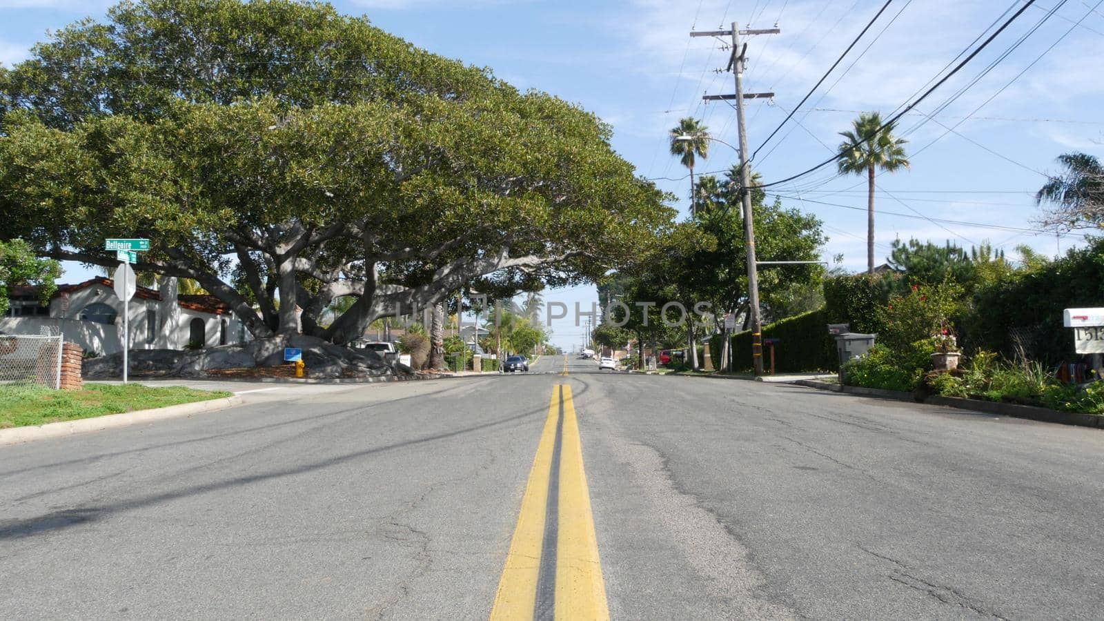 Houses on suburban street in California USA, Oceanside. Generic buildings in residential district near Los Angeles. Real estate property exterior. Tropical gardens, palms near typical american homes.