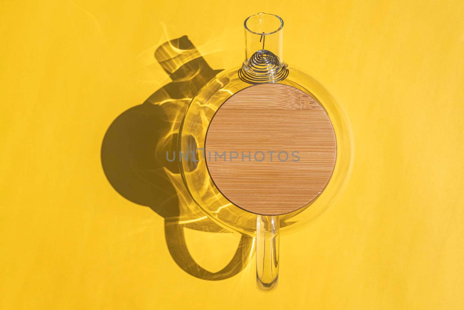glass teapot with a hard shadow on a colored background. High quality photo