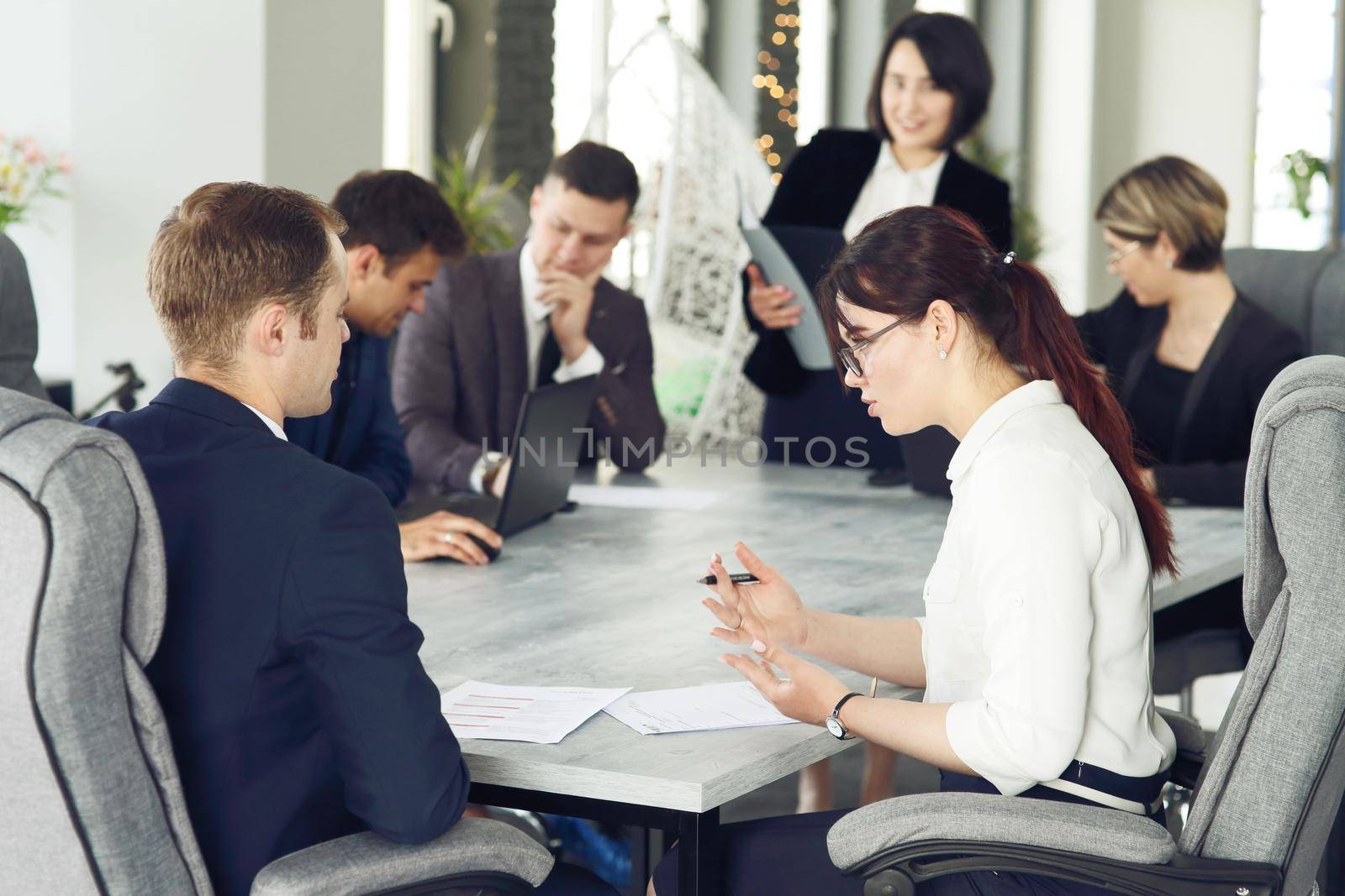 Group of young successful businessmen lawyers communicating together in a conference room while working on a project. 
